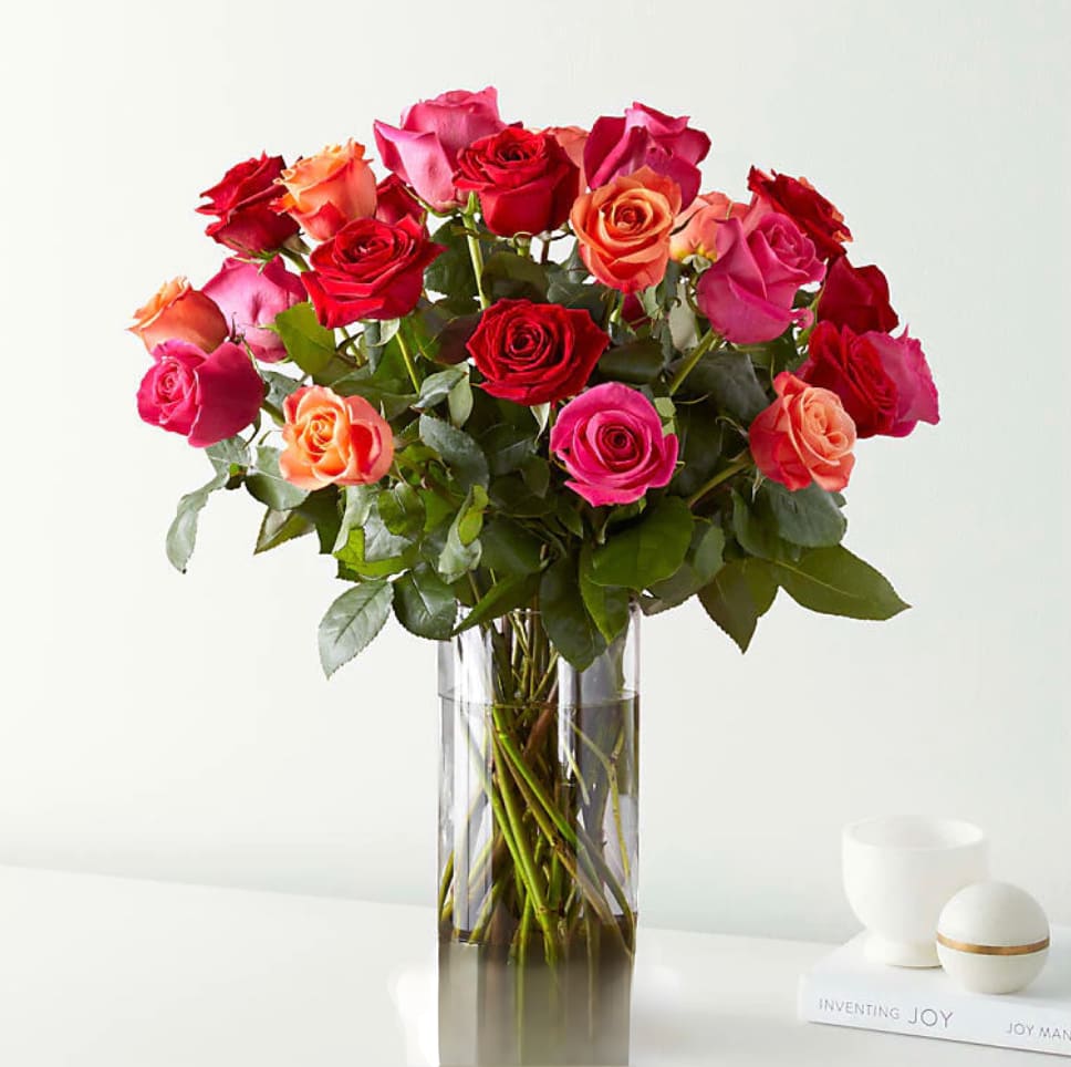 Ever After Rose Bouquet Ever After Rose Bouquet - 2 Dozen Rose Arrangement with a mix of red, orange and hot pink roses and nice greens in a clear vase.