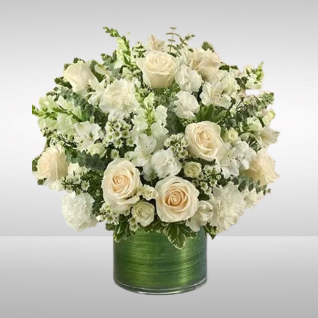 Cherished Memories - All White Cherished Memories - All White - Recipe: This striking, all-white arrangement of roses, spray roses, snapdragons, alstroemeria, carnations, mini carnations, and monte casino, gathered with variegated pittosporum and spiral eucalyptus elegantly arranged by hand in a graceful cylinder vase. Season: All year round Orientation: All Facing View Photo shown: Standard