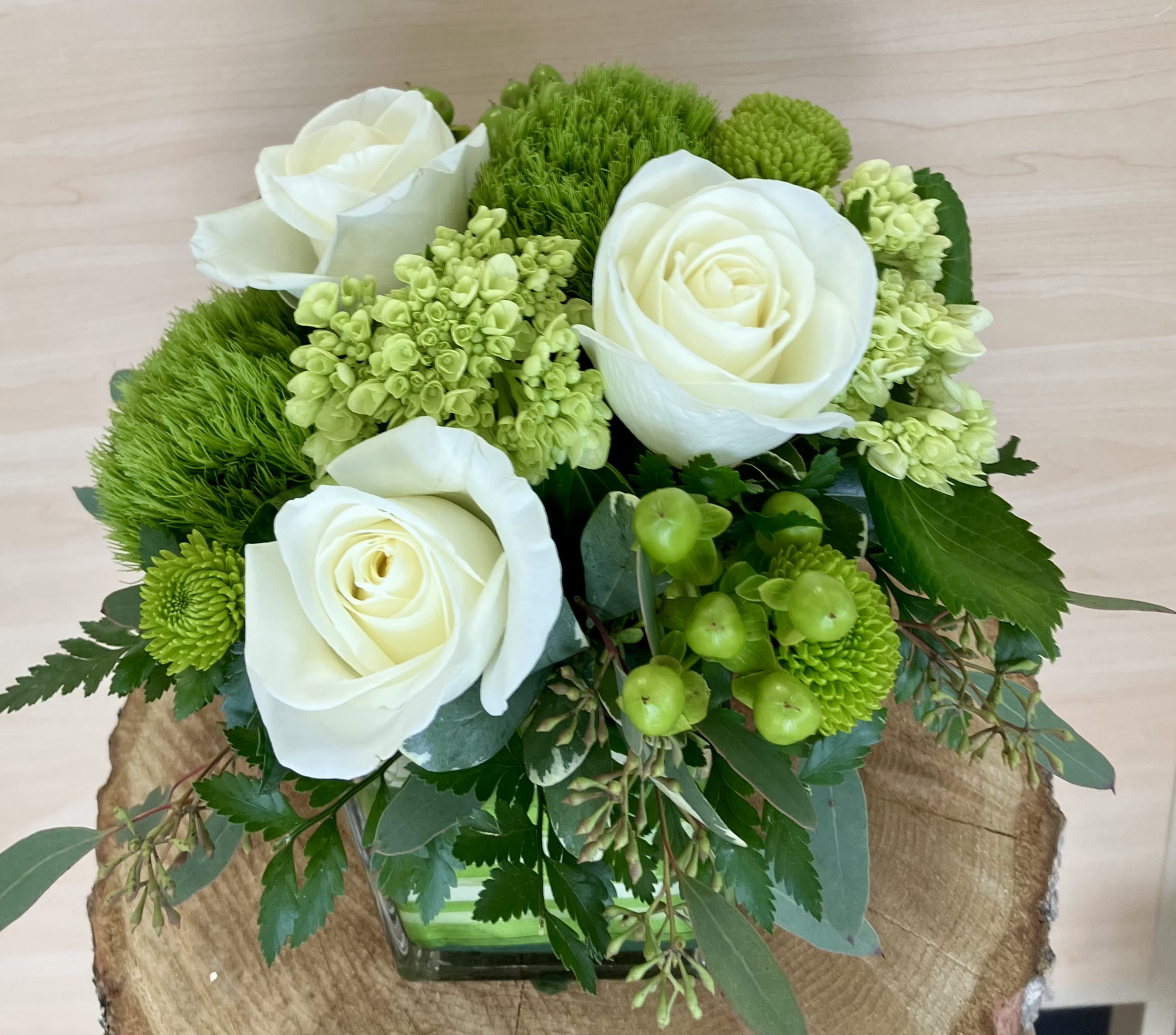 Lucky Charm Bouquet Lucky Charm Bouquet - Ruth Messmer Florist's Lucky Charm Bouquet is designed in a glass cube and include white roses, mini green hydrangea, green trachelium, and green hypericum. Sure to add a little luck and happiness to anyone's day! approximate size is 10" x 10"...want more flowers upgrade to the deluxe or premium size