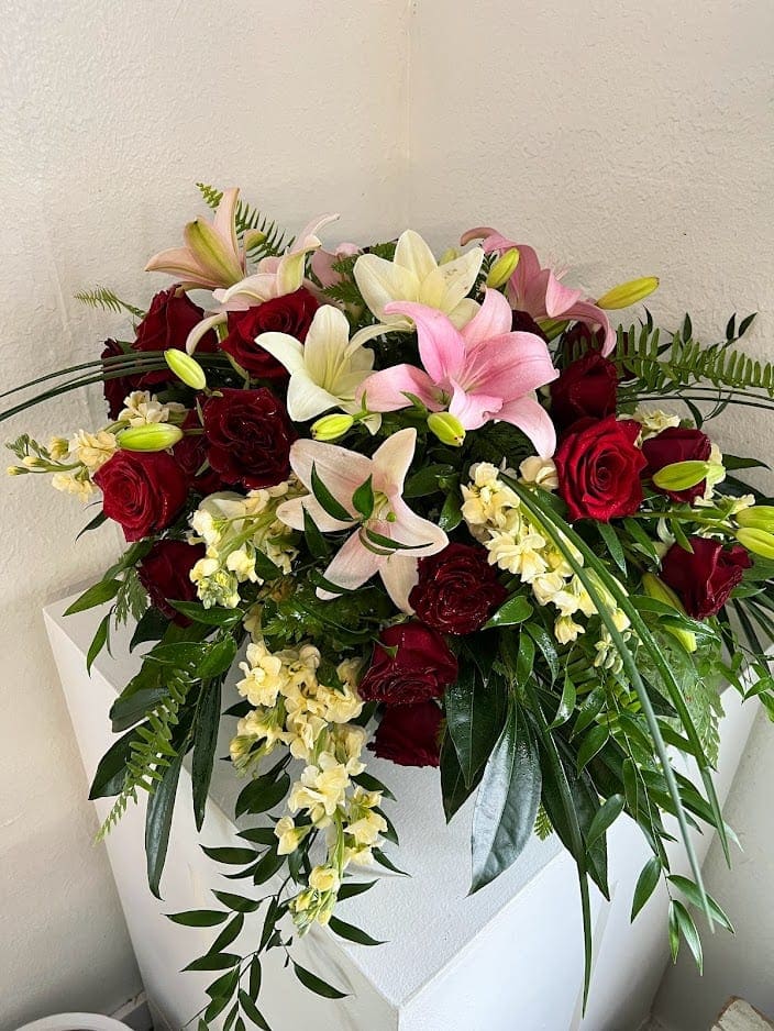 Roses and lily tribute casket spray - Red roses, white and pink lilies with assorted greenery to cover half of an open casket
