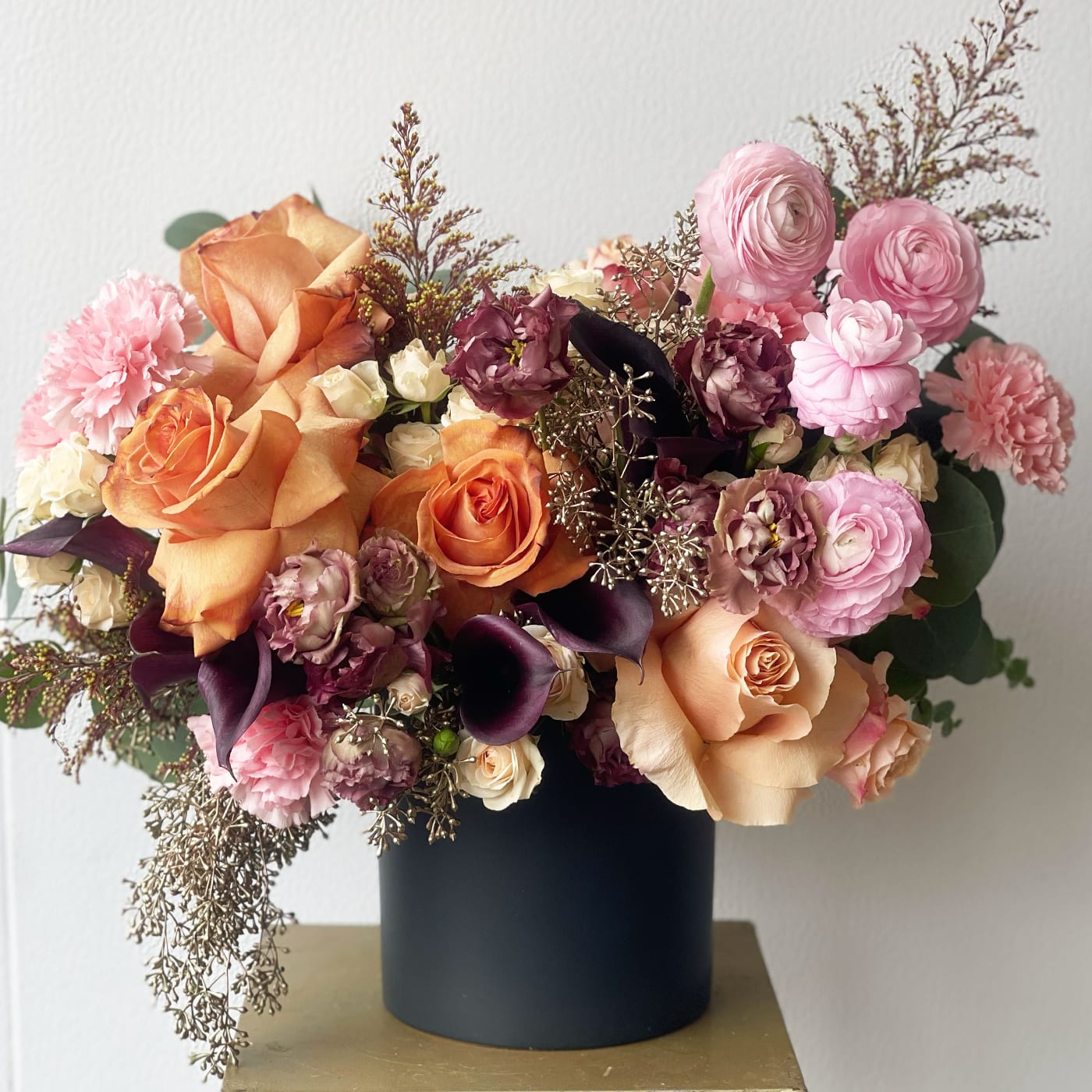 Luna de Otoño Luna de Otoño - Luna de Otoño which means autumn moon : *Disclaimer this is a ONE SIDED ARRANGEMENT* , Fall seasonal arrangement which includes - Fall themed roses, burgundy flowers, seeded euk, wild flowers, ranunculus flower, : VASE: Black Ceramic