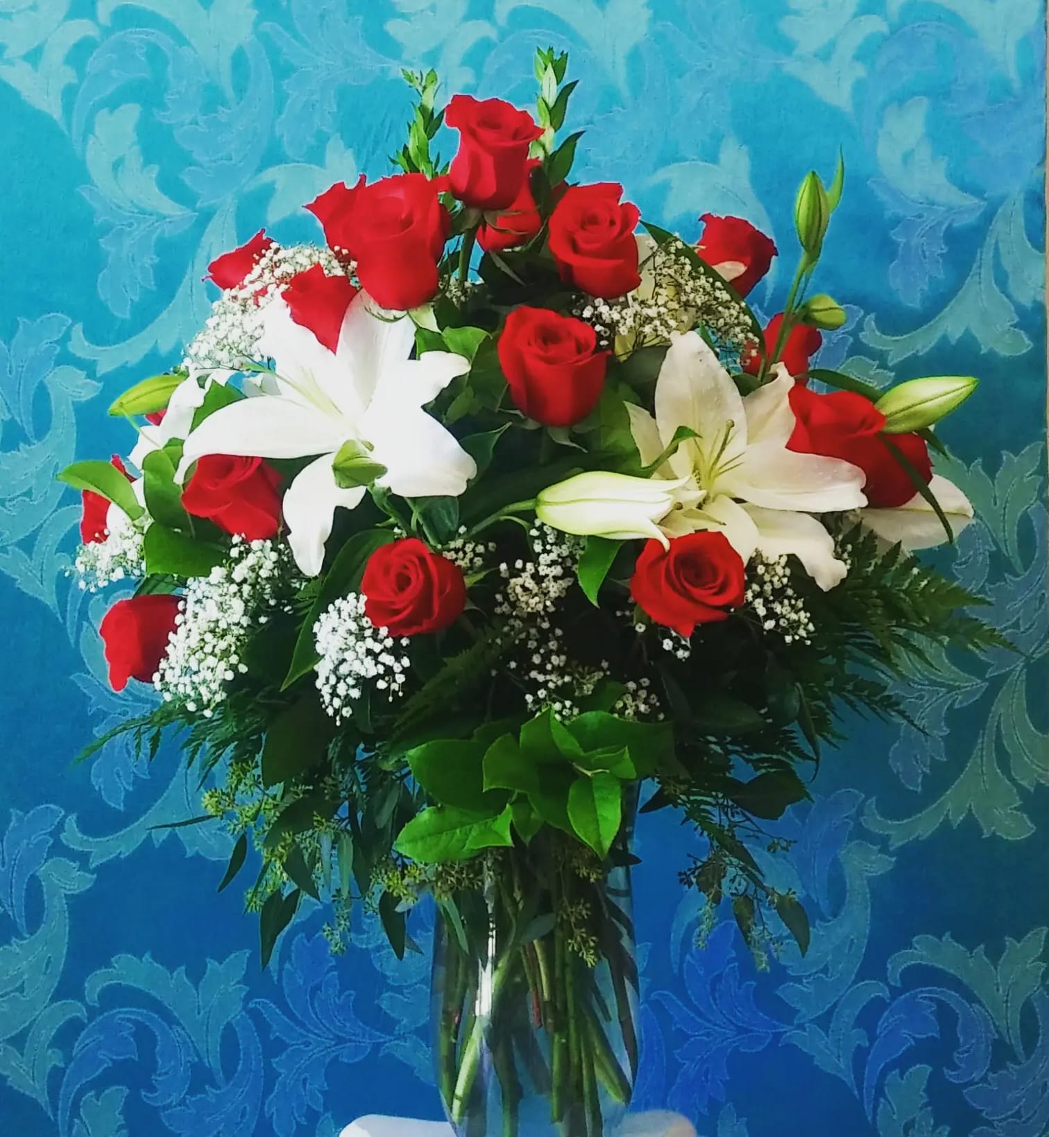 2 Dozen Grand Red Rose Lily Bouquet - 24 Long Stem Red Ecuadorian Roses traditionally designed in a large clear  vase with large white lily blooms in a full round design. This bouquet is large and gorgeous!