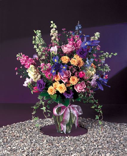 BIRTHDAY BLAST-  ON SALE WAS $98 - THIS IS A BEAUTIFUL DISPLAY OF COLOR, ORANGE AND PURPLE ROSES, PINK SNAPDRAGONS, PURPLE IRIS,  WHITE SNAPS AND LARKSPUR . APPROX. 23 INCHES TALL. TOPPED OFF WITH A BIG BOW.  A  TRUE CELEBRATION OF LIFE.