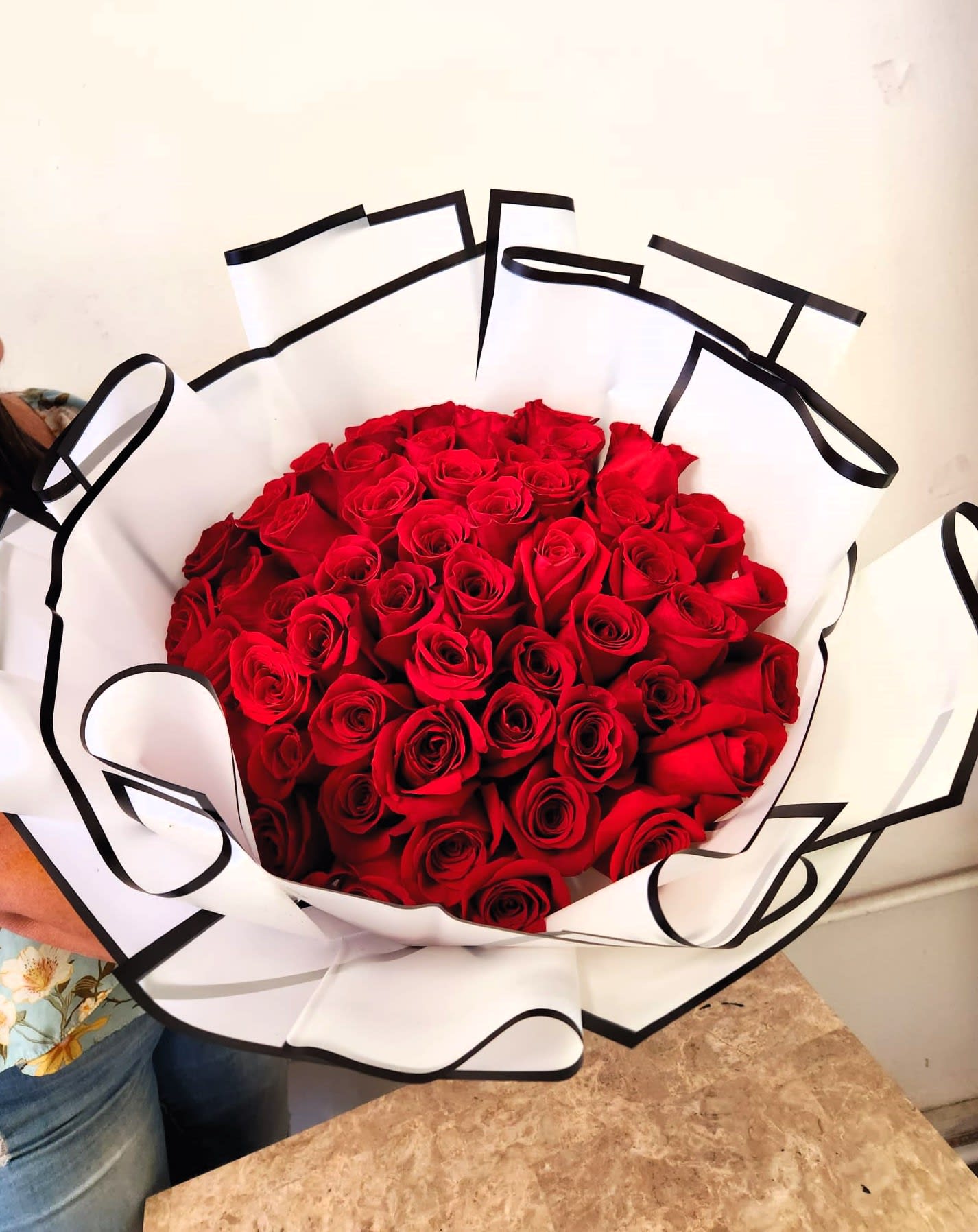 Buchon 1 - 50 roses DISCLAIMER  IF WE HAVE TO SUBSITUTE:  For flowers, we will make every attempt to match the flower type / color but may substitute with another color or type of flower. For green and blooming plants, similar plants may be substituted of equal or greater value. If the container / vase shown online is not available, a similar container / vase will be used. Bears or other gift items may be substituted as well.  Want to check on availability?  If it makes you feel more comfortable about the purchase, then we encourage you to call or email us to check on the latest availability of certain products. We would be glad to give you the most current, up-to-date status on our inventory.  Deluxe - Additional flowers will be added to enhance the bouquet.  Premium - We will add more blooms and select the highest quality flowers we offer in this style.