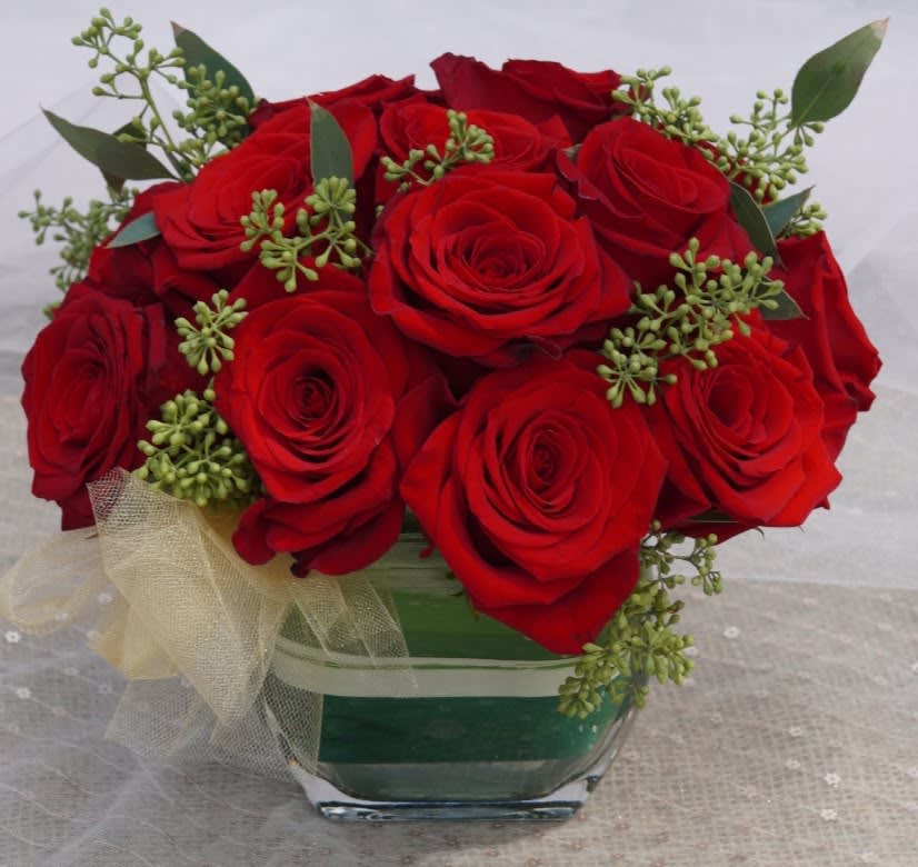 Contemporary Roses - Red - Check-out these 16 gorgeous red roses artfully arranged in a modern style.  They arrive in a contemporary clear votive surrounded by a Tai leaf.  This arrangement is perfect size for an office space or small table.    APPROXIMATE DIMENSIONS - 8&quot; in  x  6&quot; in   