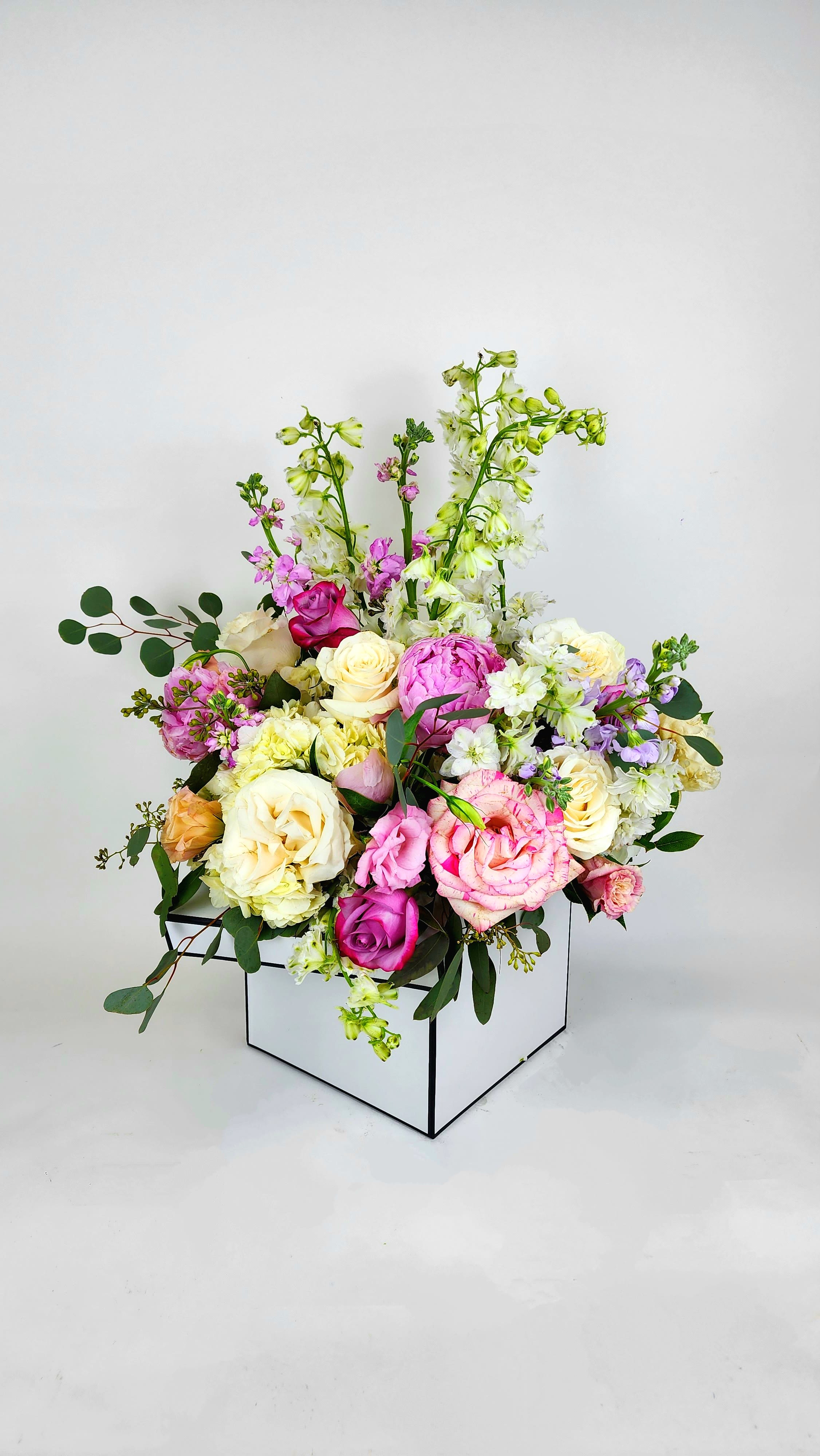 Secret Garden Box - Pastel colors flowers including roses, eucalyptus, and fillers to complete this loose design with accents of white and greens