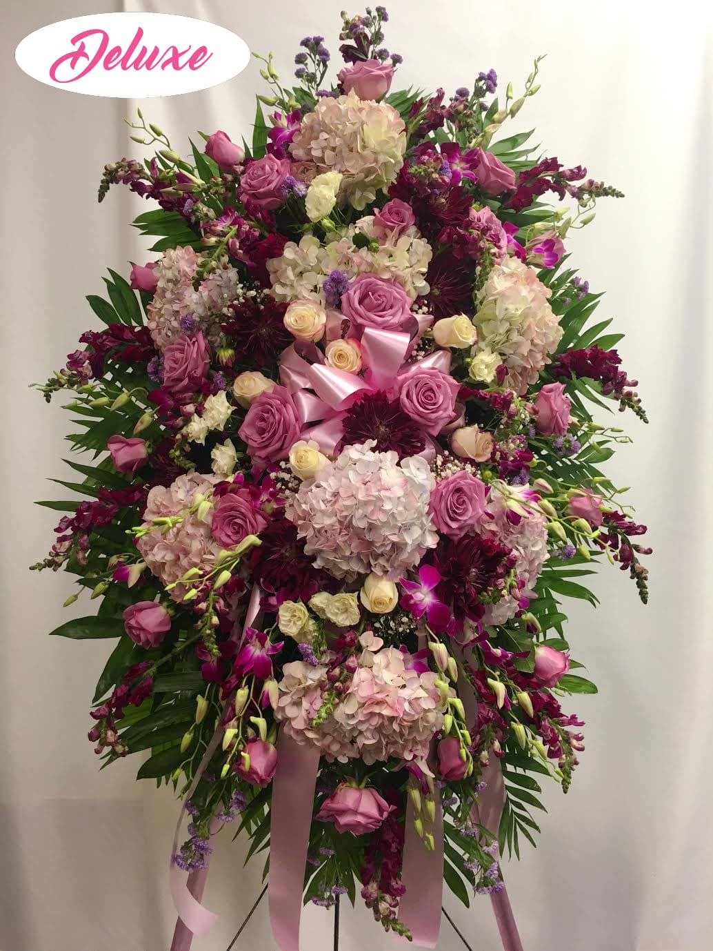 Lovely Lavender Spray - A lovely standing spray in all lavender and purple flowers. The beautiful lavender roses, compliment the light hydrangea and dark purple assorted flowers bring a nice contrast. A beautiful piece to honor any loved ones memory.