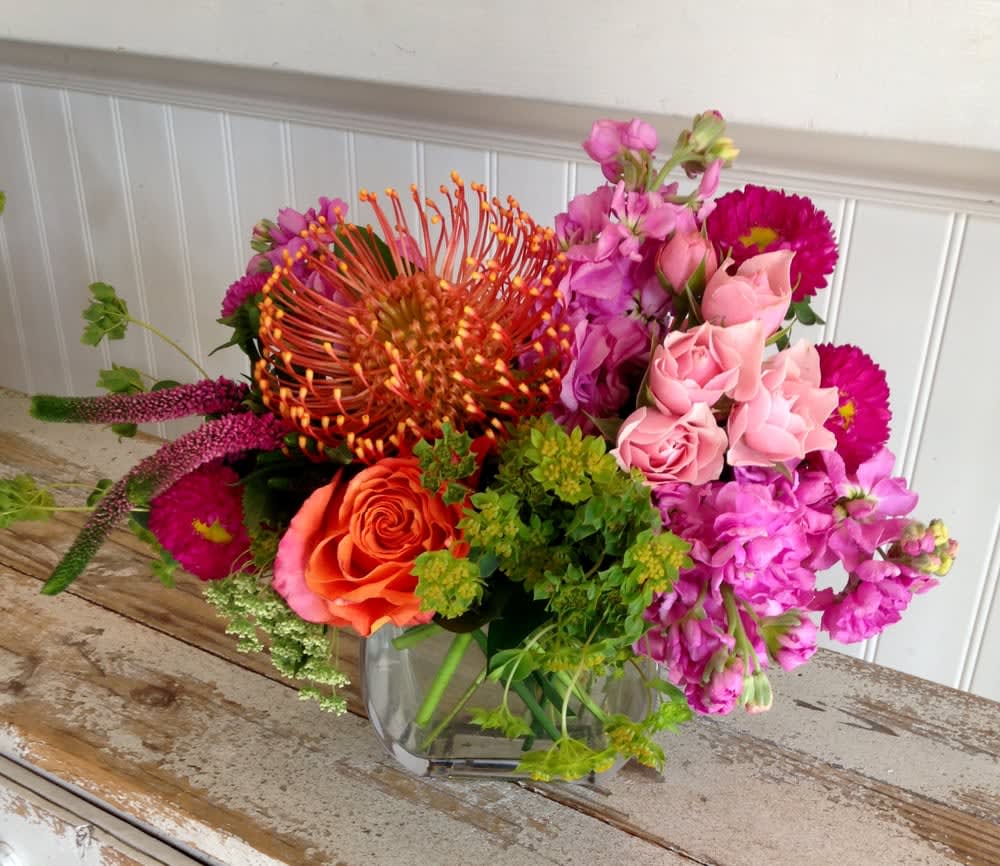 Pink Sherbet Pink Sherbet - Delicious Summery Hues make for a delightful treat!  Hot Pink Roses, Stock, Veronica and Aster with Orange Pincushions and summer greens in 5" glass cube.  A perfect way to brighten someone's day!!!