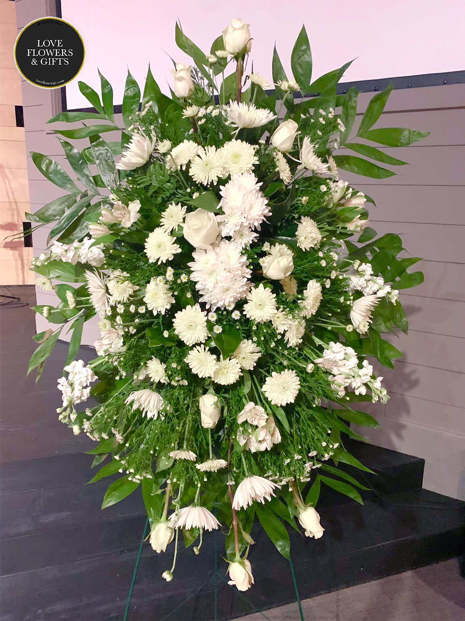 Simple White (Standing Spray) Simple White (Standing Spray) - Tall standing spray on an easel for funeral delivery. The picture shows the approximate size. This one is made of white roses, mums, and others. (Please add the funeral service time at checkout, we deliver before then) If you like us to change or add certain colors, please write in "Florists Instructions" at Checkout.