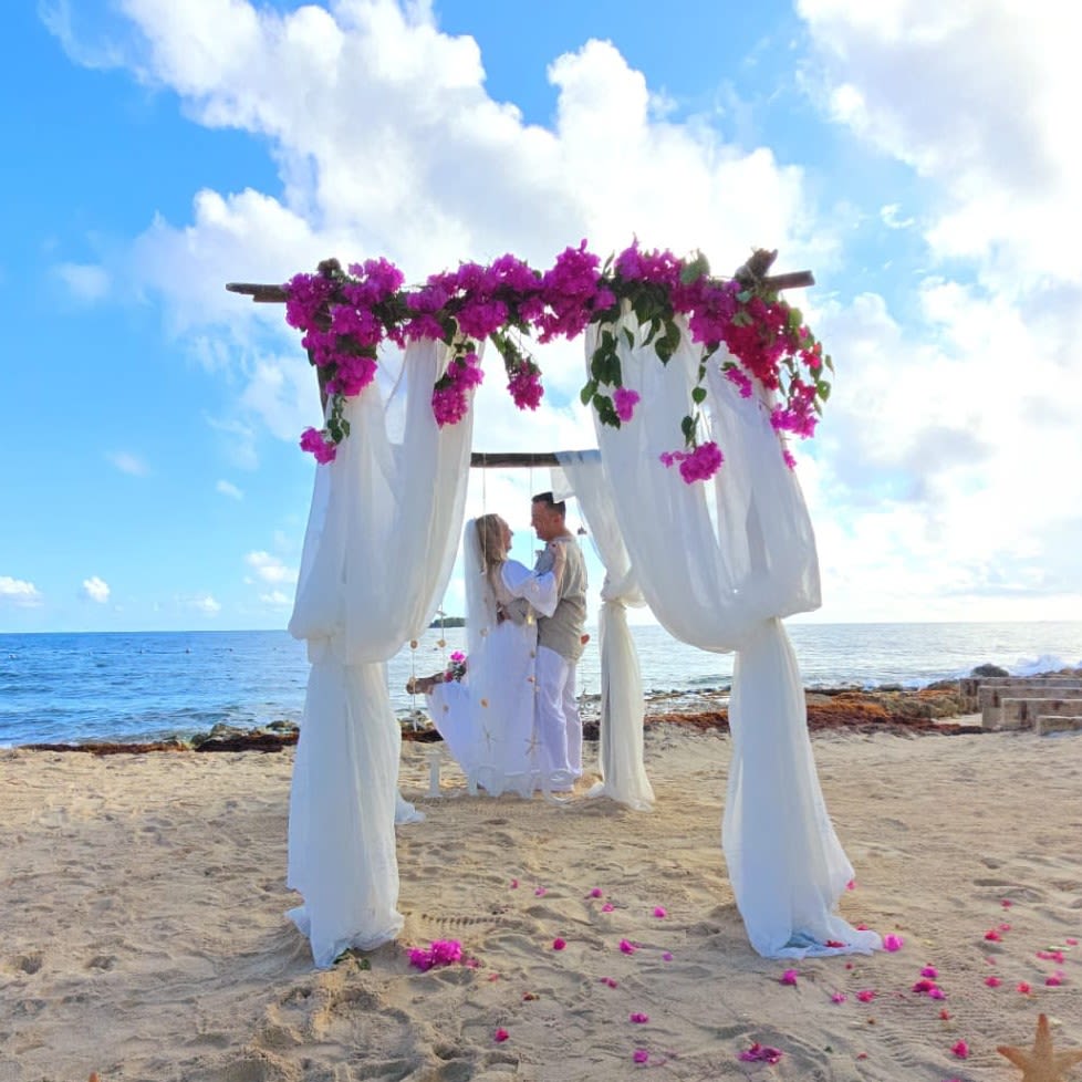Romantic Beach Wedding Arch – Dreamy Coastal Decor - Create an unforgettable oceanfront wedding experience with this stunning beach wedding arch, adorned with flowing white drapery and vibrant pink floral accents. The perfect blend of elegance and natural beauty, this setup enhances any seaside ceremony with a touch of romance and serenity.   Handcrafted floral arch with lush greenery and vibrant blooms  Ideal for beach weddings, elopements, and vow renewals  A picturesque setting for breathtaking wedding photography  Customizable floral arrangements to match your wedding theme  Event decoration and floral setup available in Los Angeles  Let your love story unfold against the backdrop of the endless ocean and golden sands. Book your dream wedding decor today!
