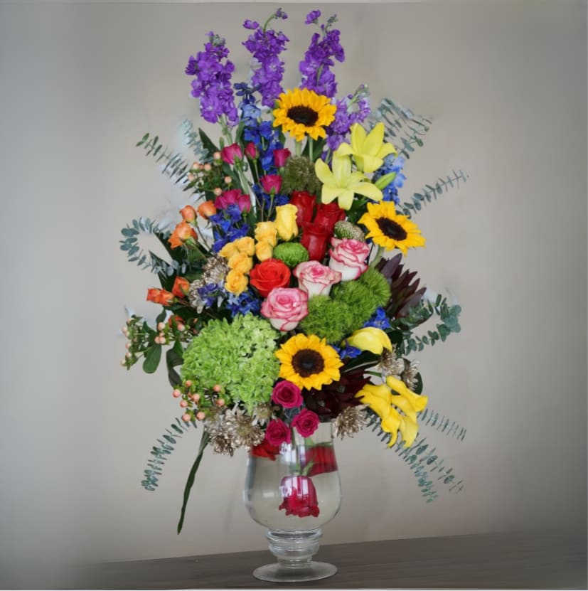 Color Burst Color Burst - Fantasy at its best. If they are a fan of vibrant lively colors then you can't go wrong with this bouquet. Grand and elegant, containing calalilies, sunflowers, green hydrangeas, multi colored roses, berries, eucalyptus, delphinium, stock and more. Whether for an event or as a gift, order our eclectic bouquet for delivery today