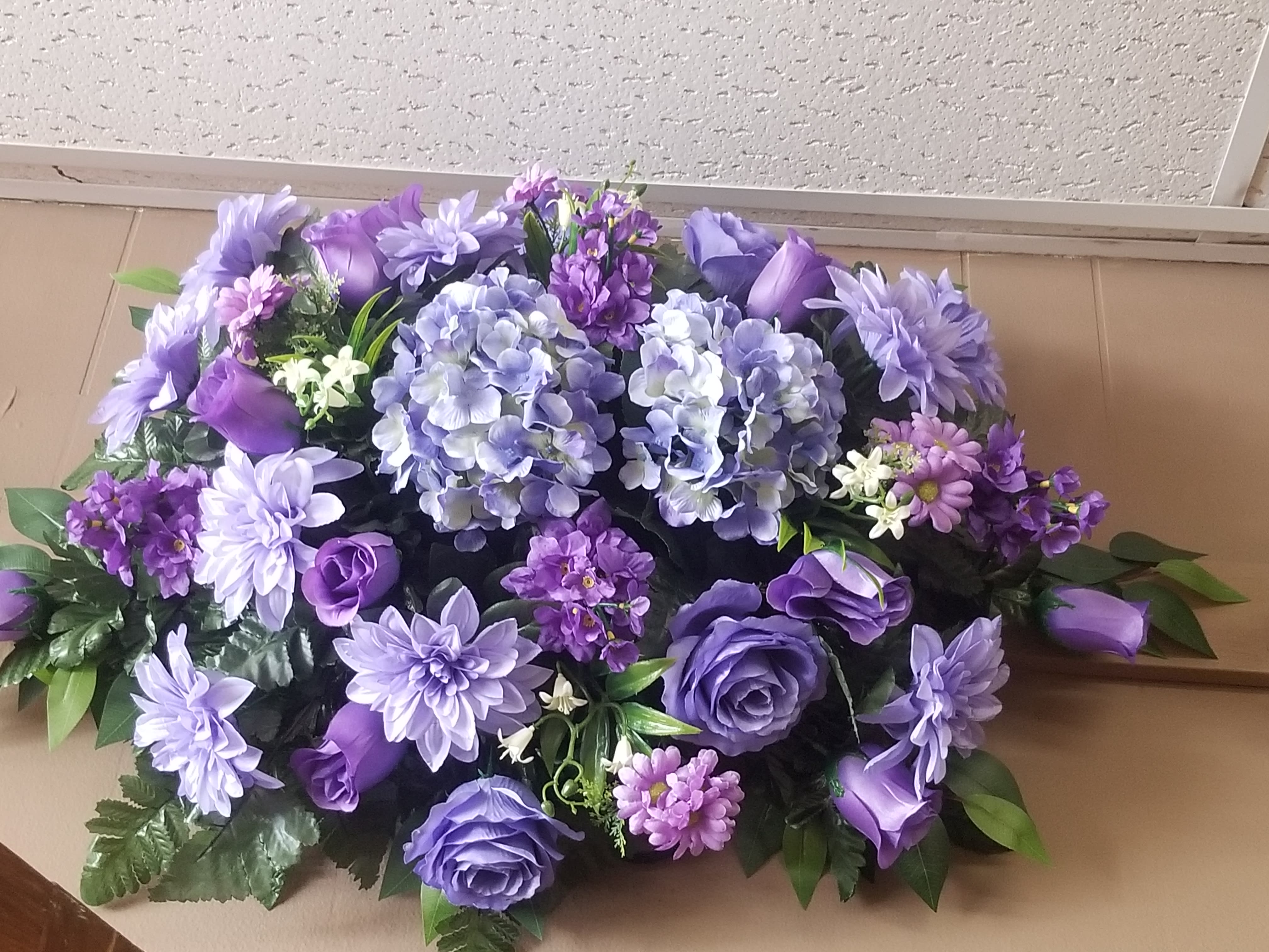 Cemetary Saddle - An artificial floral arrangement for the top of a headstone.