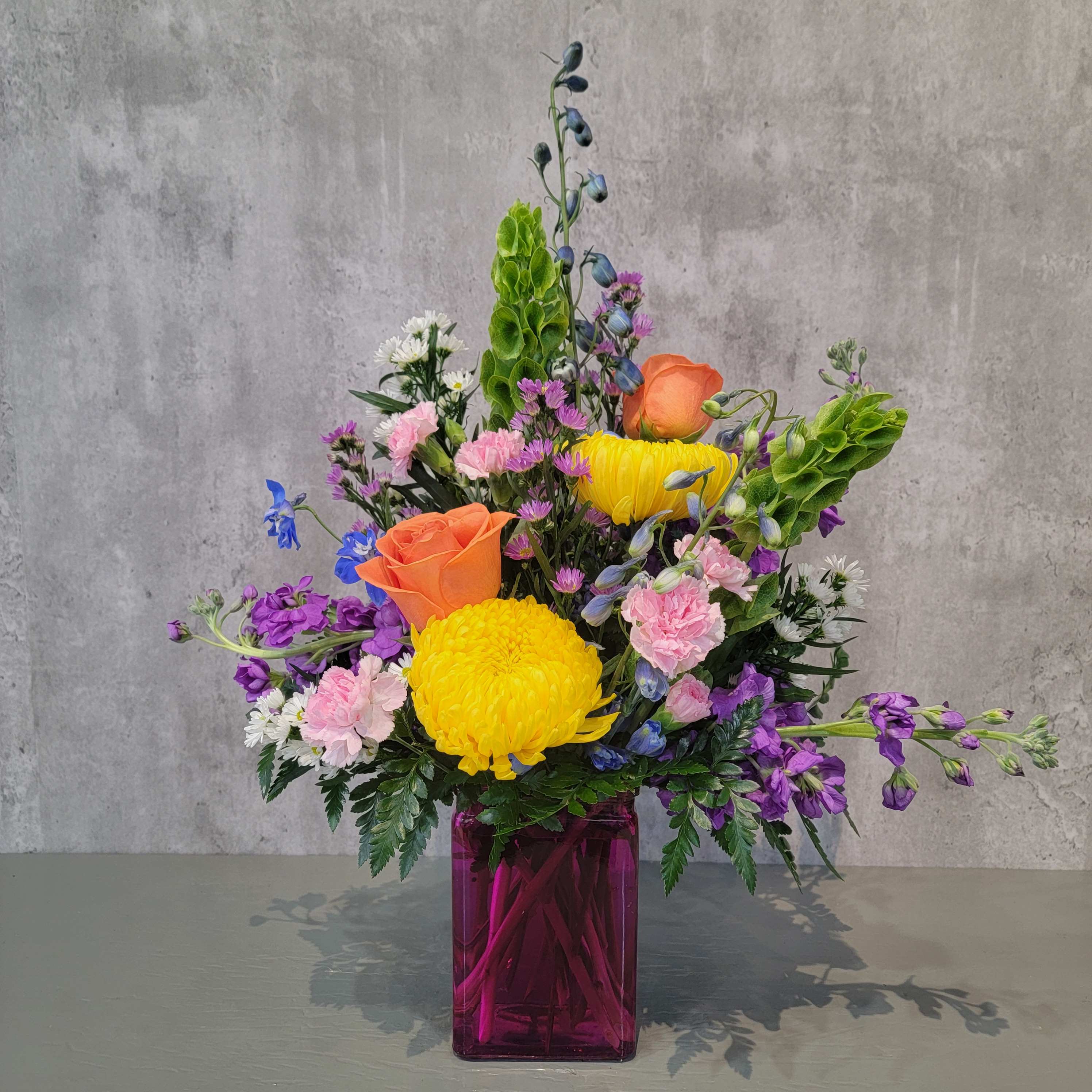 Spring in Your Step Spring in Your Step - Bright and beautiful spring flowers in a hot pink glass vase. A gorgeous way to send a friend some love today!