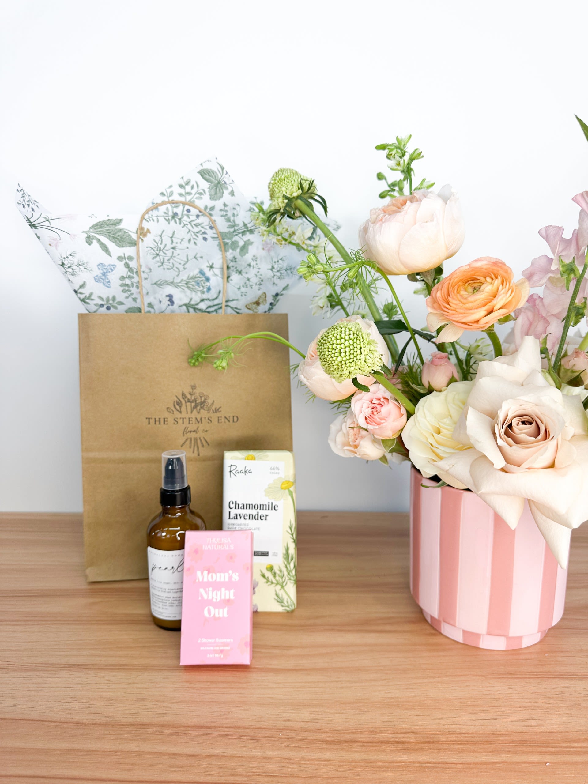 Moms Night In Bundle Moms Night In Bundle - Treat the amazing moms in your life with our Sweet Surprise Arrangements! This delightful package includes a rich Raaka chocolate bar, a set of soothing shower steamers, and a luxurious lotion, making it the perfect gift for a cozy night in. It's all about pampering and relaxation, so let her unwind and enjoy some well-deserved me-time!