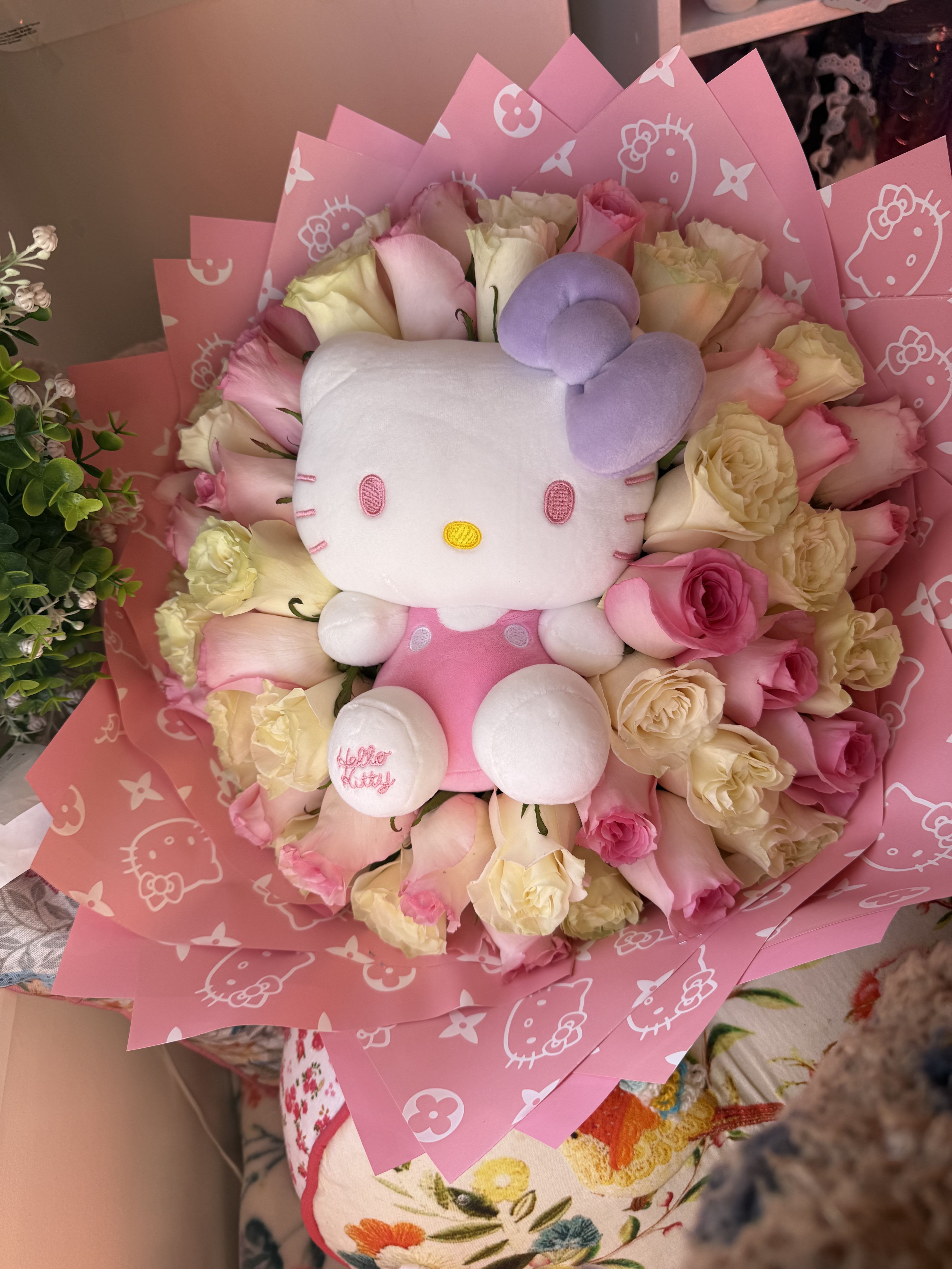 I love hello Kitty I love hello Kitty - A beautiful bouquet of 50 roses, wrapped in pink paper with Hello Kitty designs, features a Hello Kitty plush toy nestled within the flowers. The bouquet is centered in the image, filling most of the frame. Roses of various shades of pink and white are tightly arranged, creating a full and vibrant display. A Hello Kitty plush toy is prominently featured in the center of the bouquet, adding a playful touch to the arrangement.