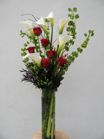 1/2 DOZEN ROSES AND 1/2 DOZES CALLAS IN TALL DESIGNER VASE 1/2 DOZEN ROSES AND 1/2 DOZES CALLAS IN TALL DESIGNER VASE - Bouquet with red roses and white calla lilies.