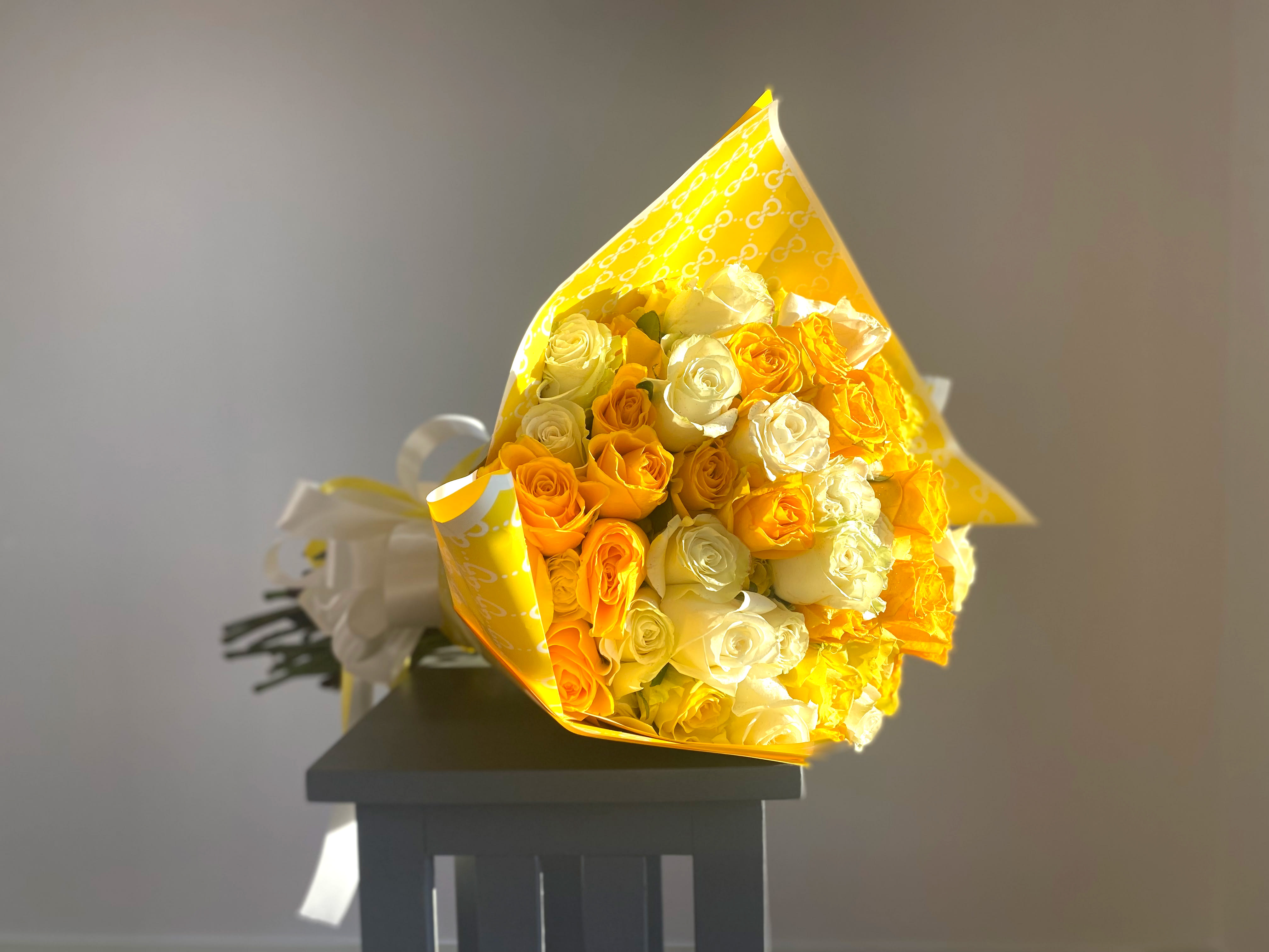 Laos (100 Roses) - Luxury at its finest with this one right here. Large golden yellow and white bloomed roses wrapped in gucci print, perfect for any occasion set to steal the show! Approx. 100 Long Stem Rose Blooms