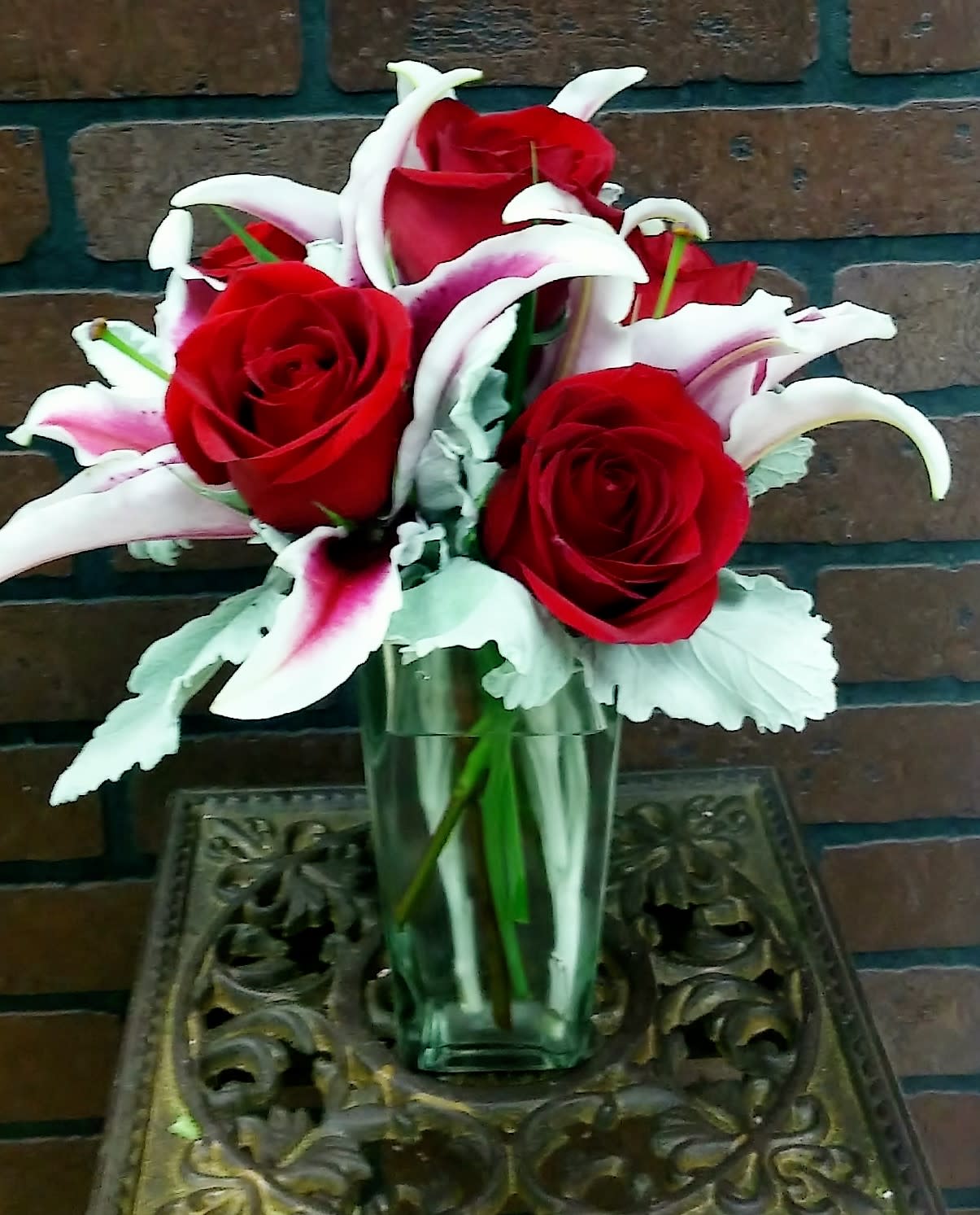 Roses and Stargaziers Roses and Stargaziers - Our premium red roses are accented with the fragrance of these beautiful stargazer lilies nestled in a beautiful glass vase. Makes a perfect gift to set on her desk at the office for any occasion.
