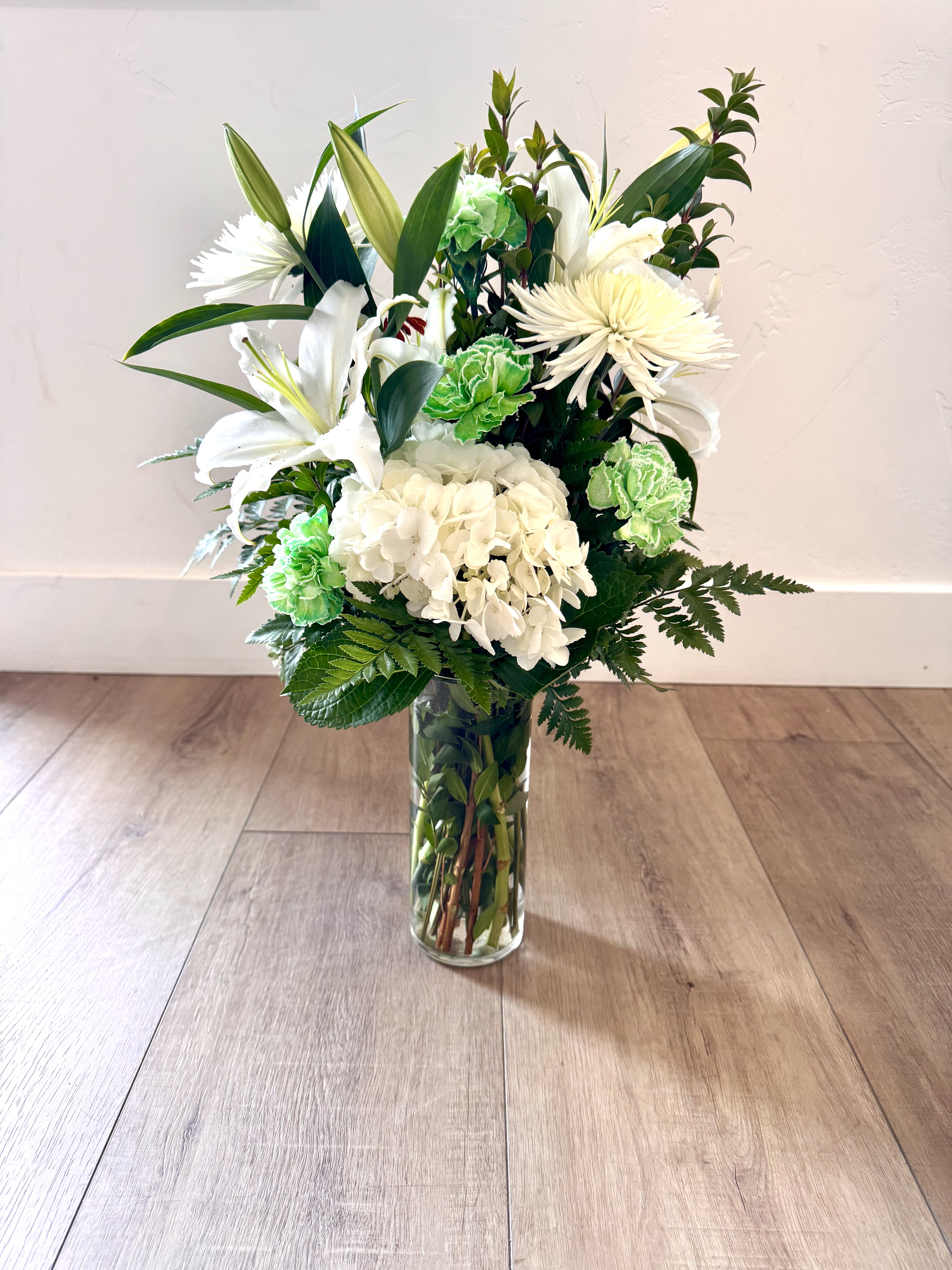 Luck of the Irish Luck of the Irish - Featuring White Hydrangea, White Lily's, White Poms, Tinted Green Carnations, and Fill