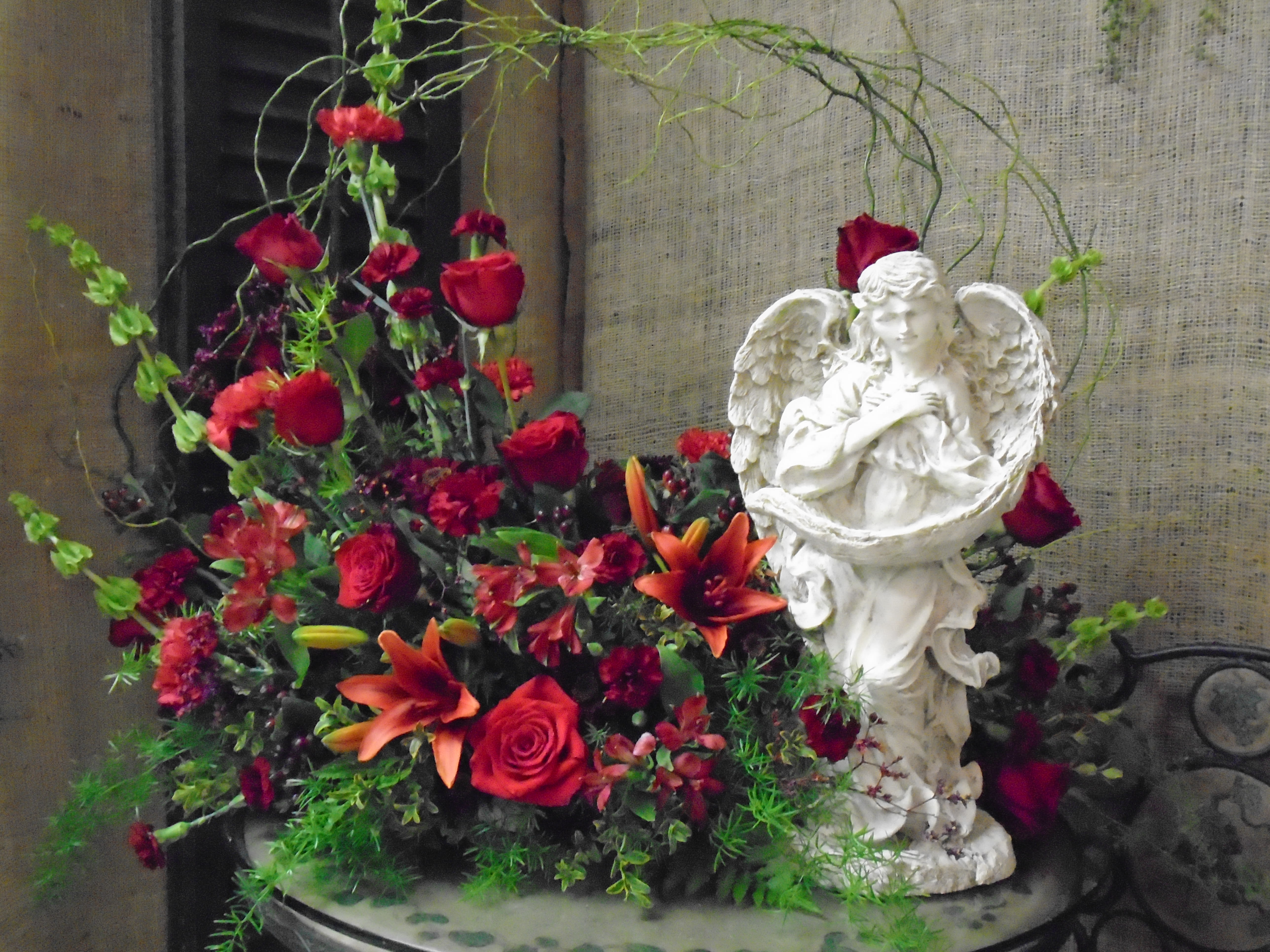 Large Red Fresh Arrangement with Concrete Angel Large Red Fresh Arrangement with Concrete Angel - Large Red Fresh Arrangement with Concrete Angel designed by Haehn Florist in Wapakoneta, OH 45895 *Keepsake gifts will be very similar as our suppliers change their inventory with trends.