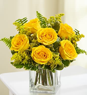 Love's Embrace - 6 Roses - Product ID: 1052136  Brighten any celebration with a beautiful and brilliant bouquet of exquisite long-stem yellow roses. Hand-designed by our select florists, it's a stylish and vibrant gift that's sure to bring sunny smiles to their day. Our florists select only the finest, freshest long-stem yellow roses and arrange them by hand with fresh solidago Available in bouquets of 6 stems, 3 stems or a single yellow rose 6-stem arrangement in an 5&quot;H glass cube vase measures approximately 7.5&quot;H x 5.5&quot;L 3-stem arrangement in a glass bud vase measures approximately 16&quot;H x 4&quot;L Single-stem arrangement in a bud vase measures approximately 16&quot;H x 4&quot;L Our florists hand-design each arrangement, so colors, varieties, and container may vary due to local availability