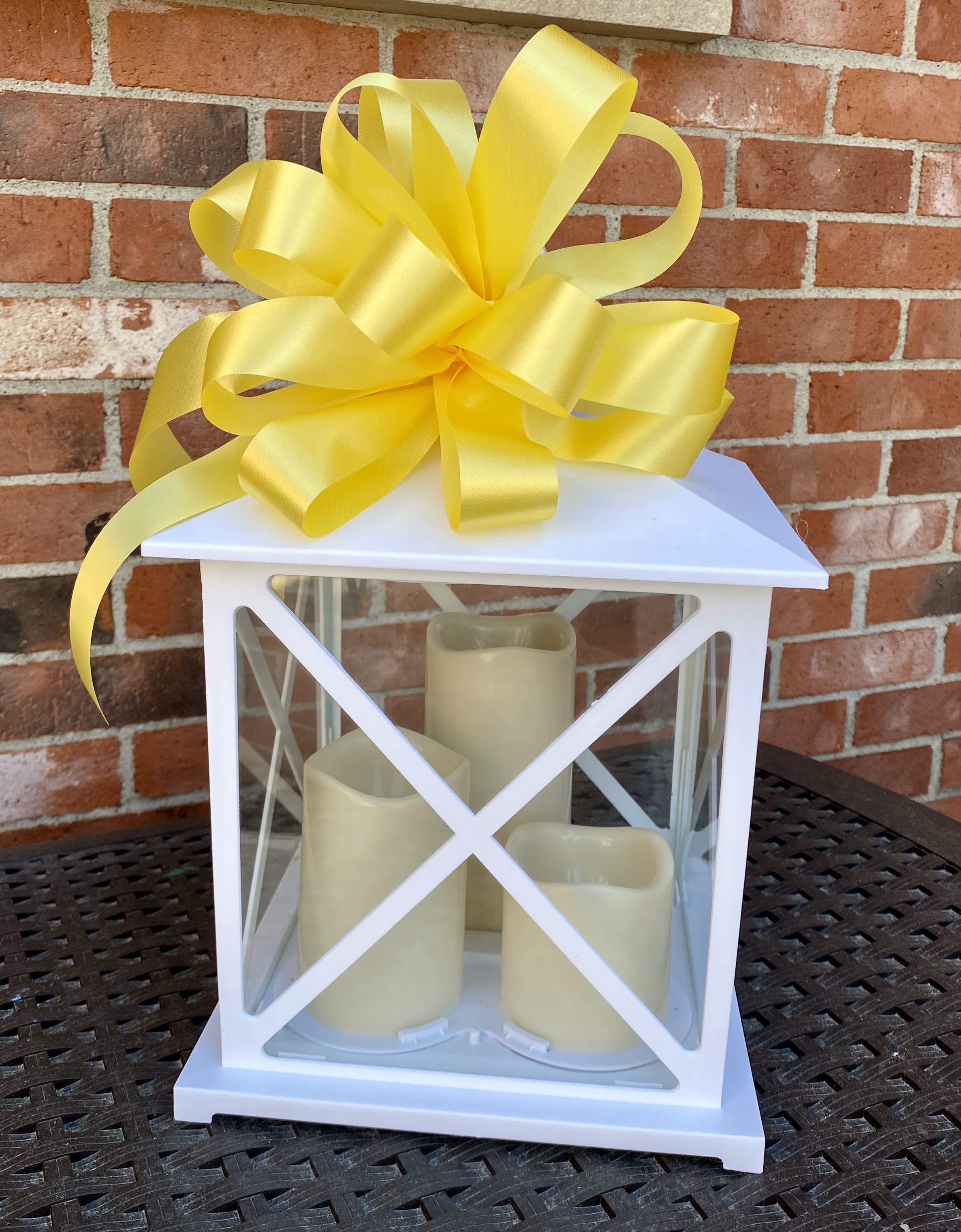 Elegant White Triple LED Lantern - This beautiful white lantern comes with three LED candles of differing heights and a timer. Perfect for a variety of occasions, the square lantern is approximately 15” tall and 9” wide. It comes complete with a decorative ribbon. 