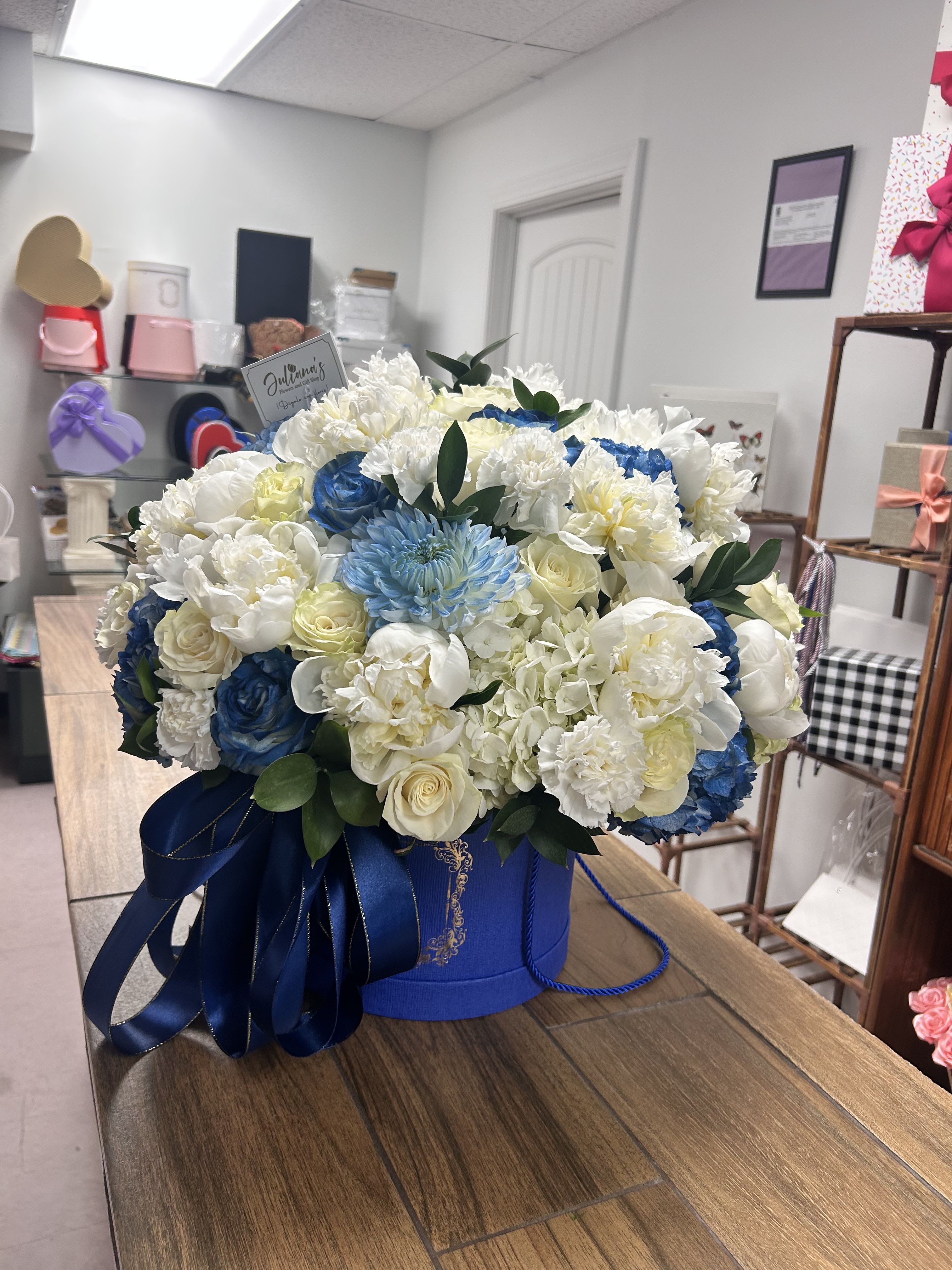 Floral arrangement in a large round box  - Floral arrangement in a large round box with assorted seasonal flowers.  Arreglo floral grande con flores variadas de la temporada