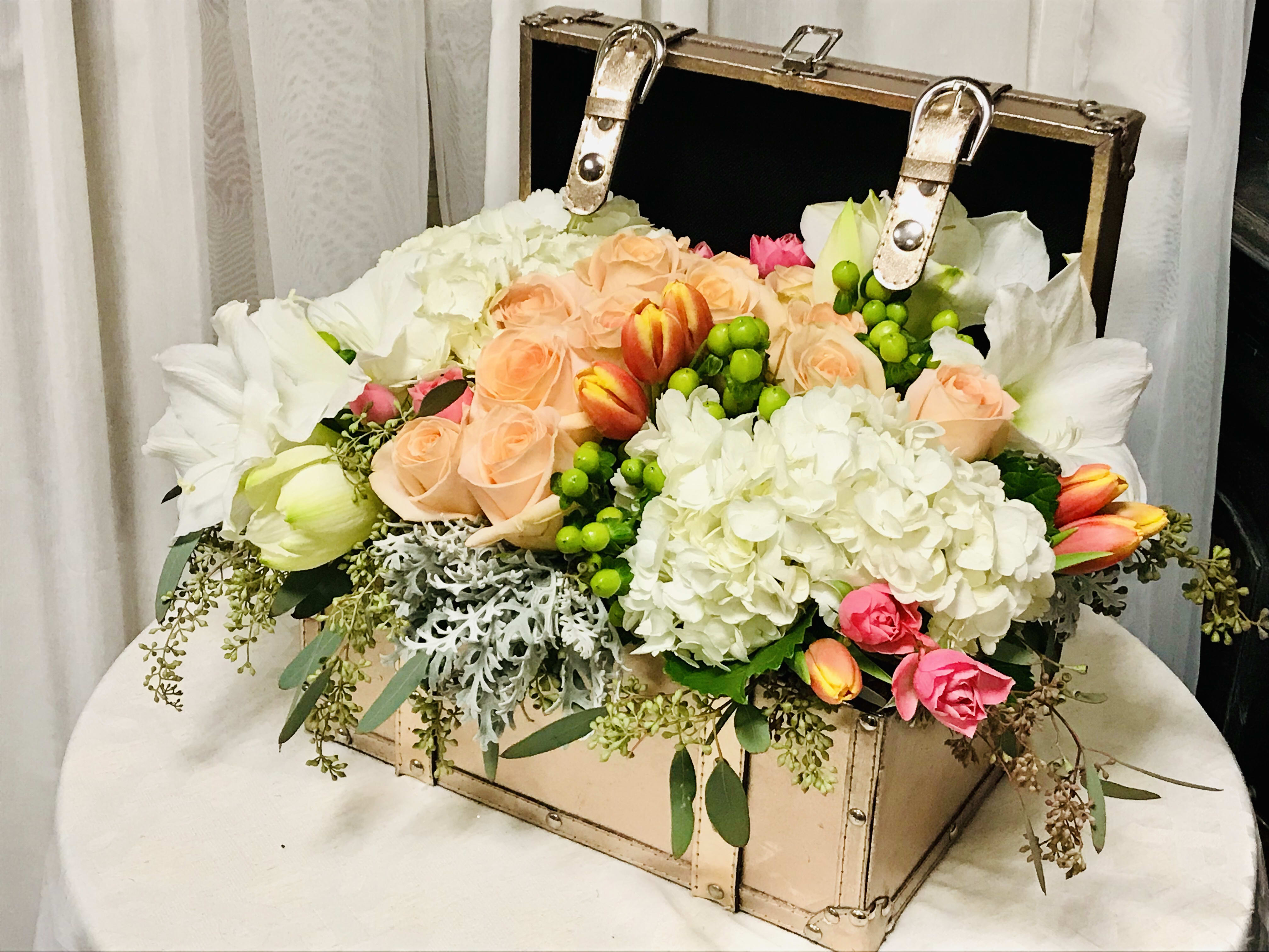 Treasured Love - Blooms of hydrangeas , roses, and tulips fill up this stunning golden leather chest. In beautiful peaches, creams, and pale pinks this gorgeous display is the perfect way to tell your loved ones how much you treasure them.