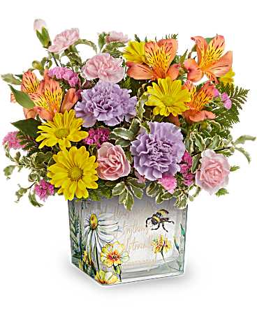 Floral buzz bouquet - This delightful arrangement features vibrant orange alstroemeria, lavender carnations, miniature pink carnations, yellow daisy spray chrysanthemums, and pink sinuata statice, all beautifully accented with leatherleaf fern and pitta negra. It is presented in Teleflora's Floral Buzz Cube, making it a charming addition to any tablescape. 