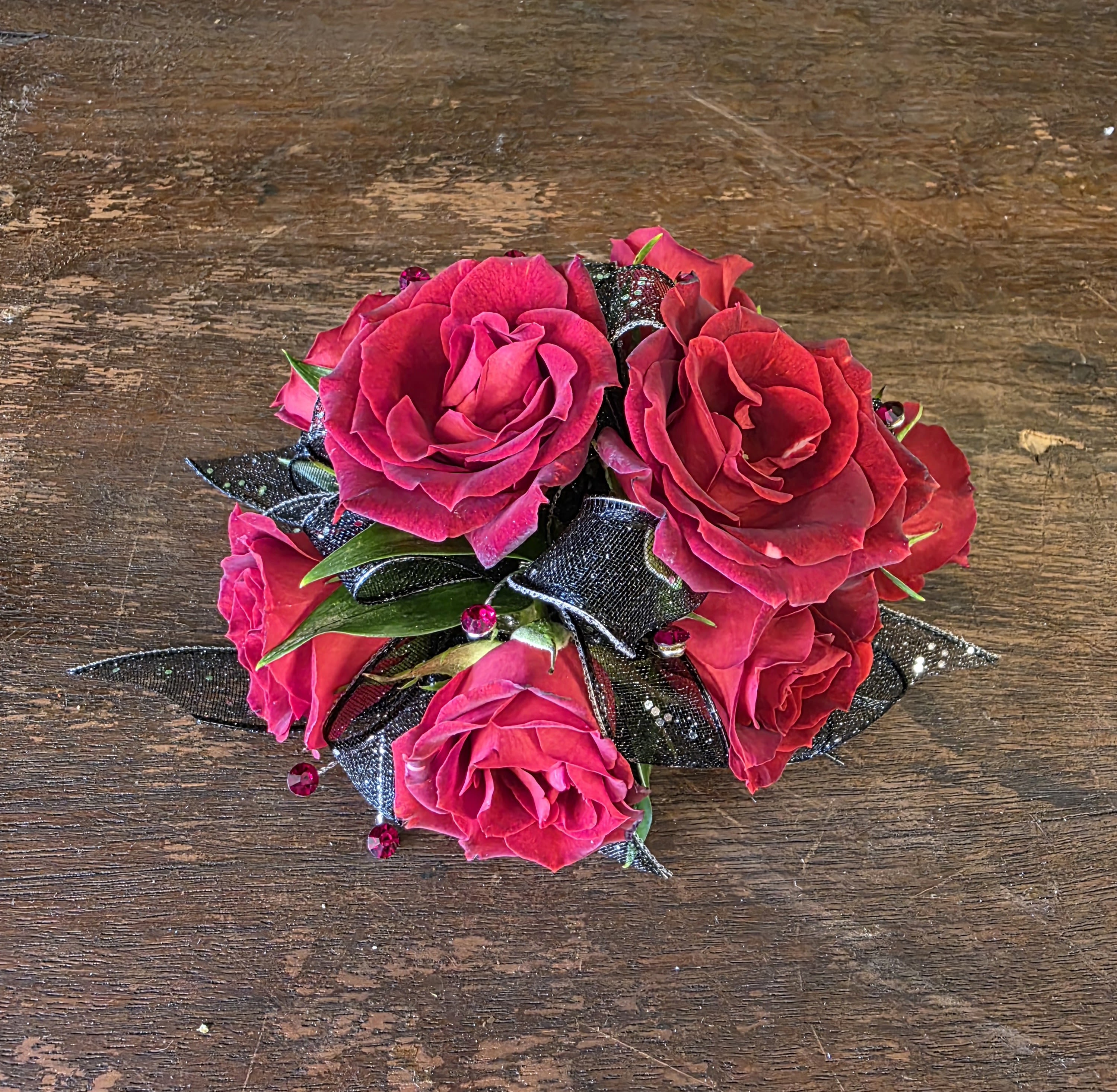 Red Wrist Corsage - Wrist Corsage Featuring Red Spray Roses, Black Sparkle Ribbon, Red Rhinestones And Greenery.