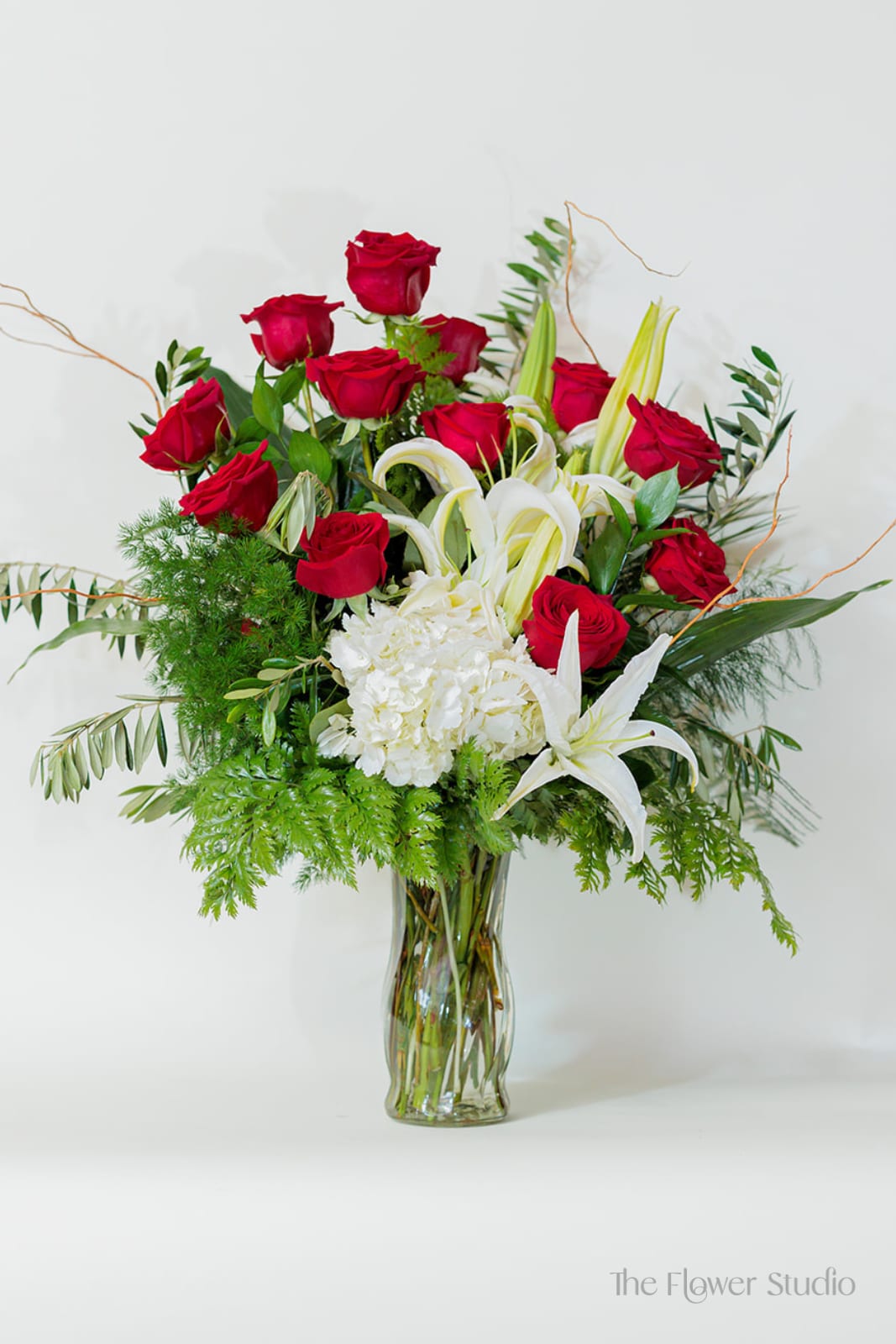 Scarlet - Bold, elegant, and full of grace, this stunning arrangement combines the timeless beauty of red and white blooms with lush greenery. Perfect for any special occasion, this arrangement is a true celebration of beauty and elegance.  Approx.  H27” x W25” 