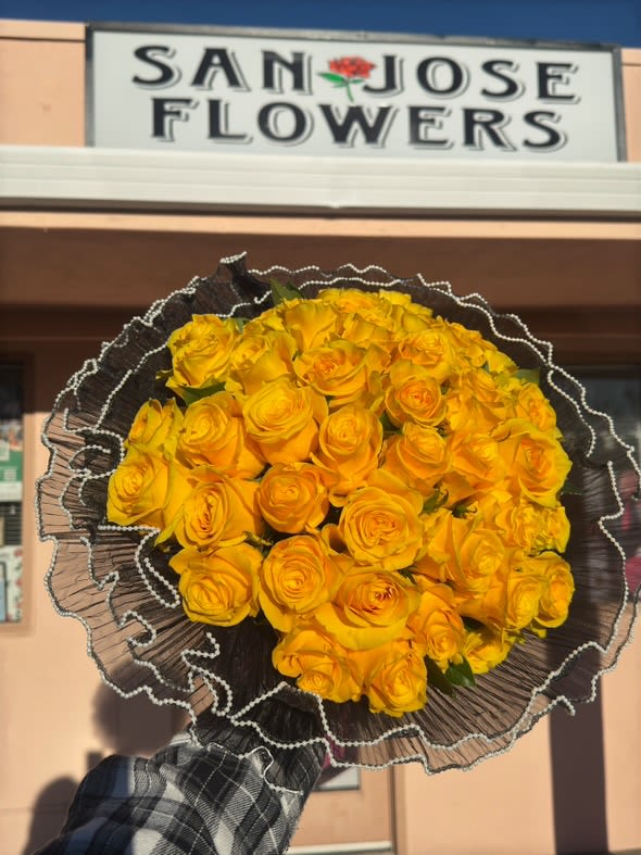 Golden Glow Bouquet  - A vibrant and cheerful bouquet of golden yellow roses, wrapped in elegant black mesh and delicate beaded edges. Prefect for celebrating joy and brightness. 