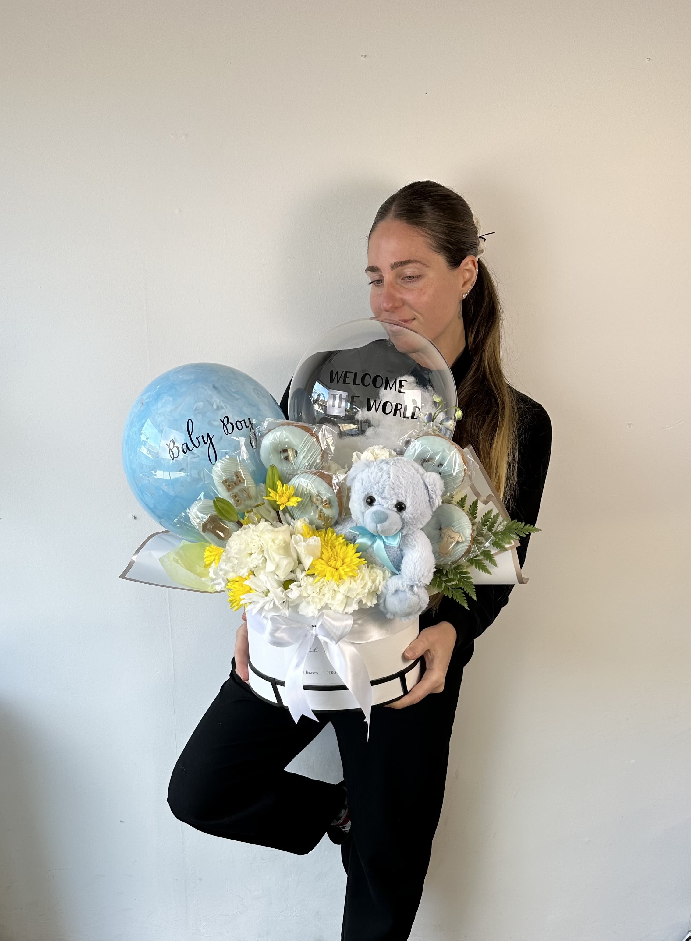 New Born Arrangement - Surprise them with the perfect new born gift combination!  Our luxury gift offers fresh flowers expertly designed in a floral modern box, along with fluffy teddy bear, special personalized balloons and hand-made sweet treats such as chocolate covered donuts, cakesicles and chocolate bars.  We kindly ask to add to the order notes your color preference and description for the balloon. A short sentence is recommended.  Standard box includes: 1 teddy bear, 2 chocolate treats, 1 personalized balloons and flowers. Deluxe box includes: 1 teddy bear, 4 chocolate treats, 2 personalized balloons and flowers. Premium box includes: 1 teddy bear, 6 chocolate treats, 2 personalized balloons and flowers.  Box dimensions: S - 7.5&quot; x 5.5&quot; h M - 9&quot; x 5.75&quot; h L - 10&quot; x 6&quot; h 