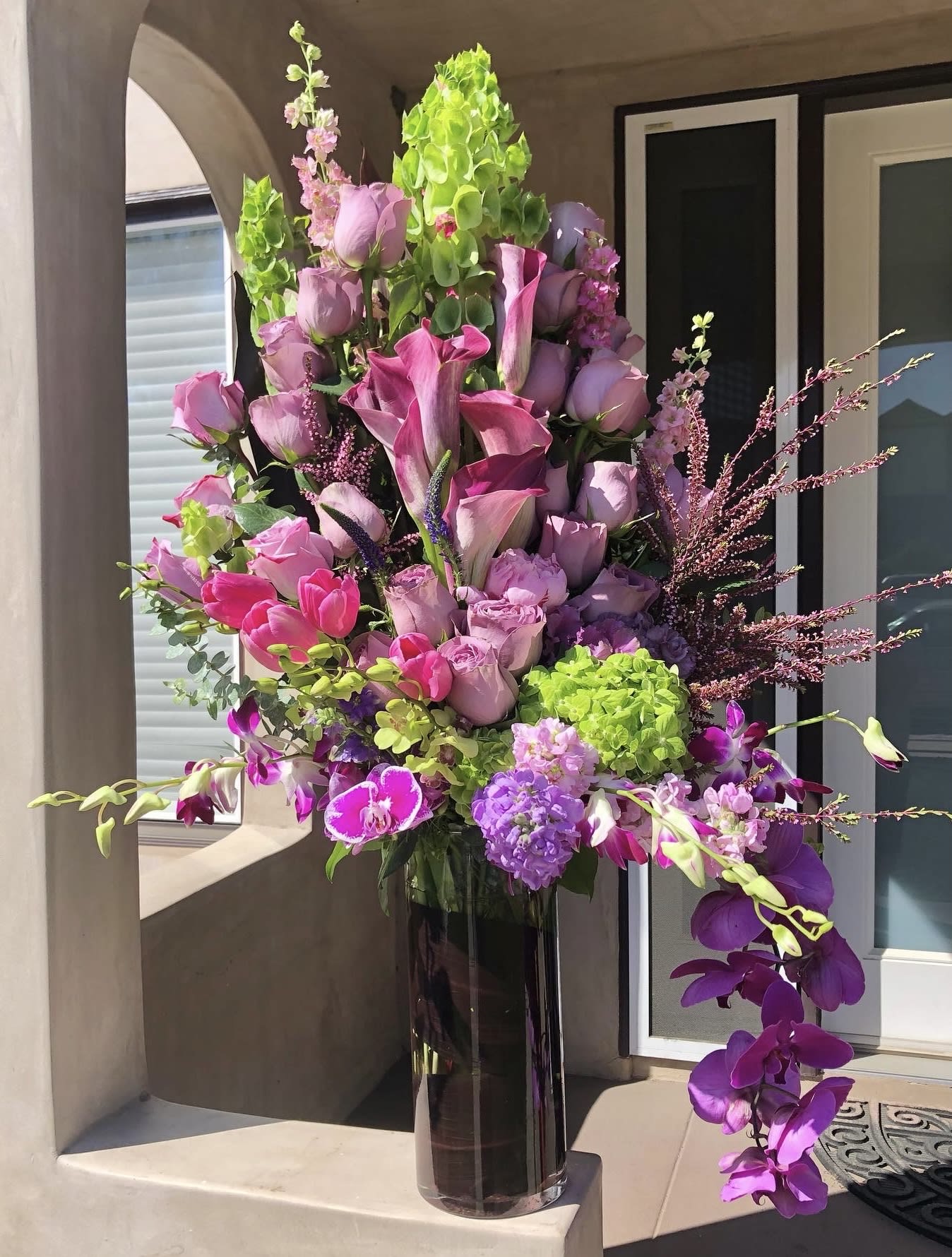 Shades of Purples - This eye-catching arrangement will make you look up and down and make whoever is receiving this EXTRA special! Seasonal varieties include roses, bells of Ireland, calla lilies, tulips, hydrangeas, dendrobium orchids, and much more!