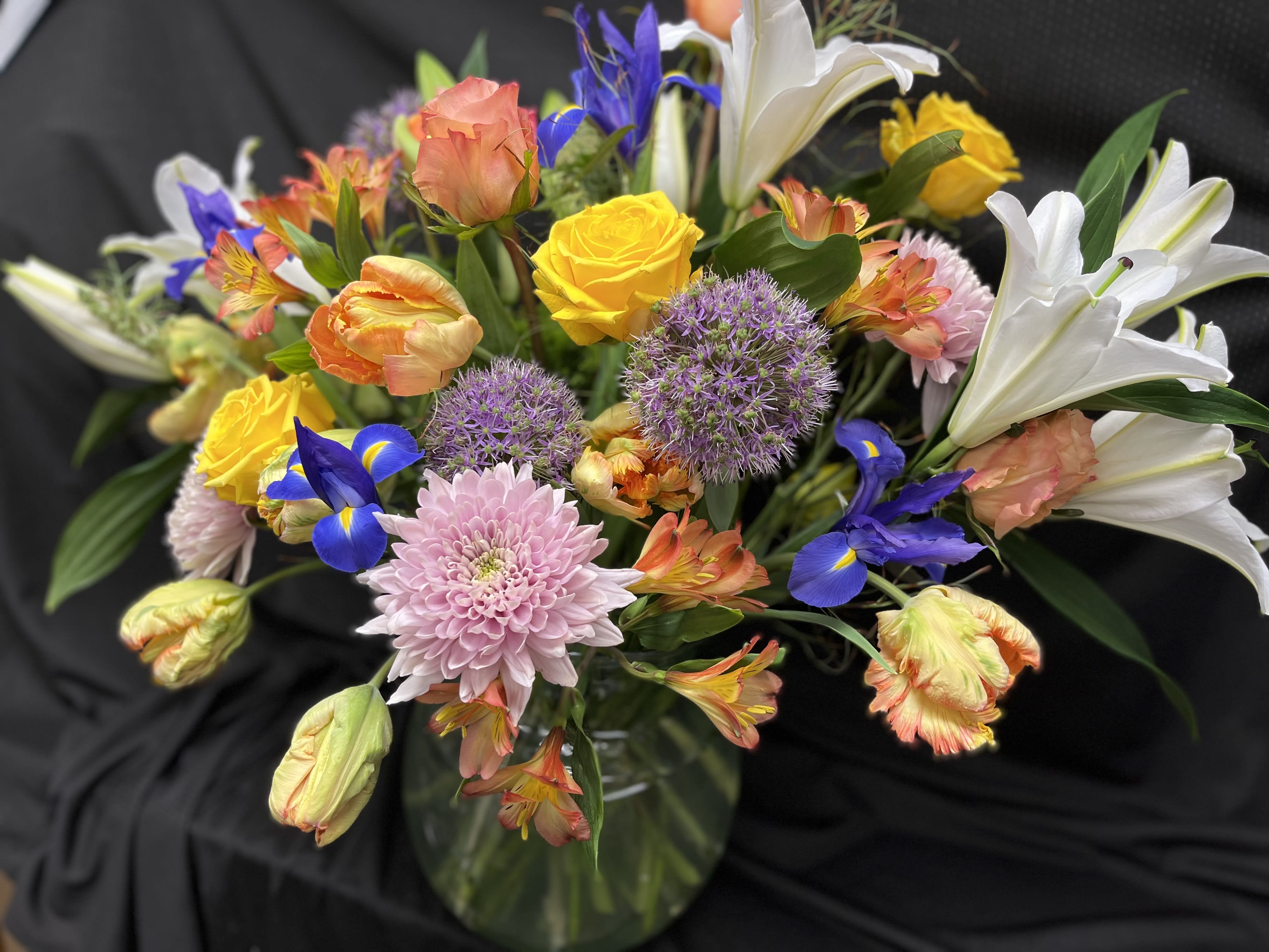 Spring Blooms - This beautiful ginger vase arrangement is made up of roses,  tulips, lilies, iris, and cremons.