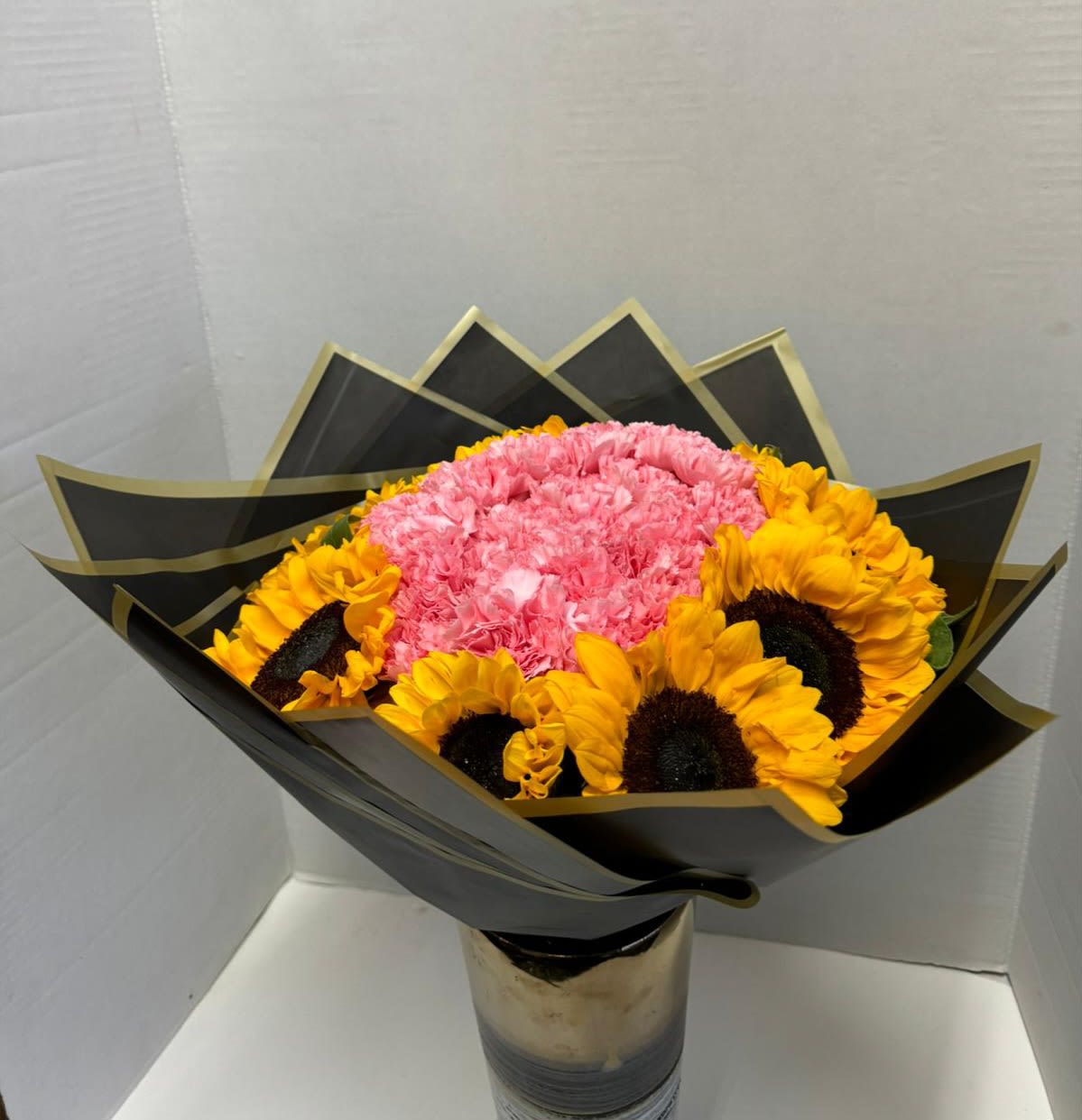 Carnations and Sunflowers bouquet  - Give the gift of a Happy Day with this stunning bouquet featuring sunflowers and beautiful carnations in shades of pink. Its tropical design, featuring deep green foliage, is ideal for any special occasion.