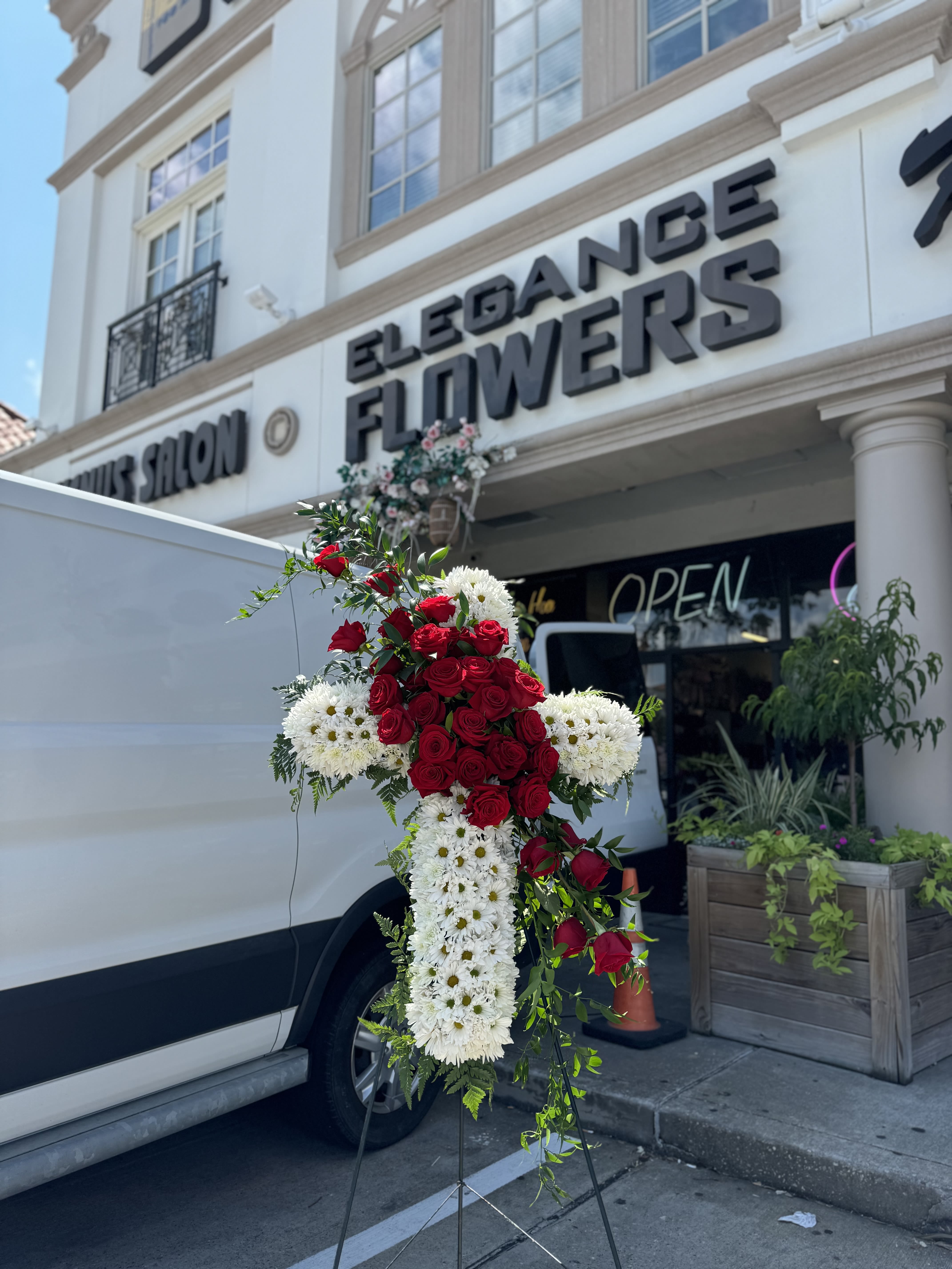 Cross Stand #1 Cross Stand #1 - A cross stand for a funeral is a graceful tribute, symbolizing faith and remembrance. Adorned with fresh flowers, it stands as a comforting centerpiece during memorial services.