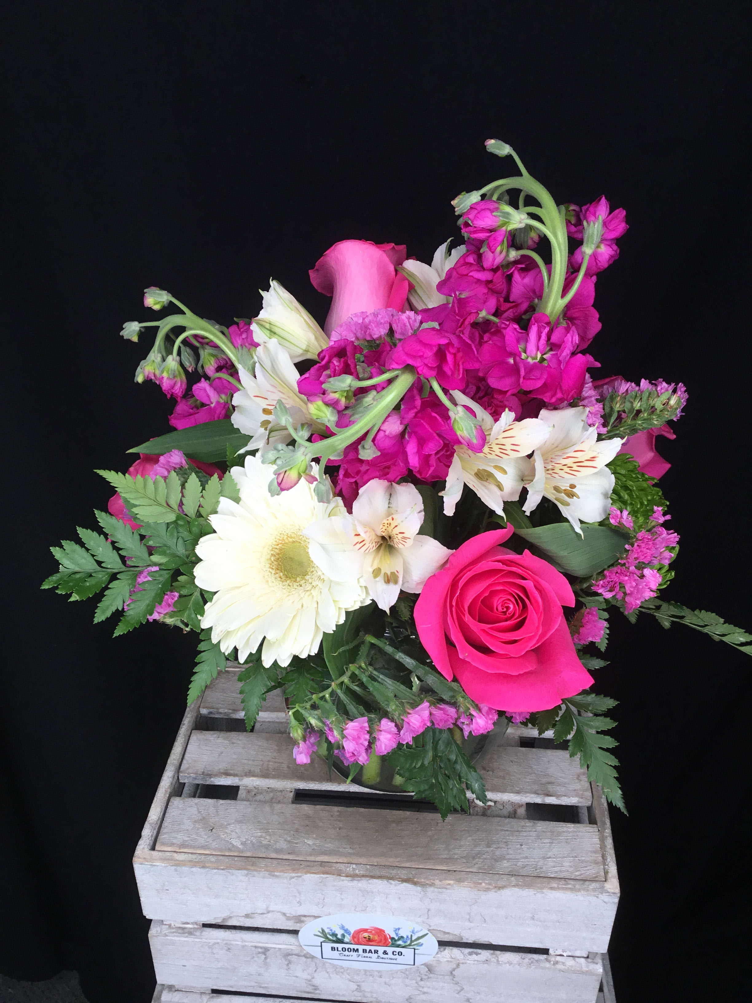 The Sangria The Sangria - Want to send something sweet? This fuchsia and white arrangement says it all. Mums, roses, gerbera daisies, and stock flower make this a vision in pink