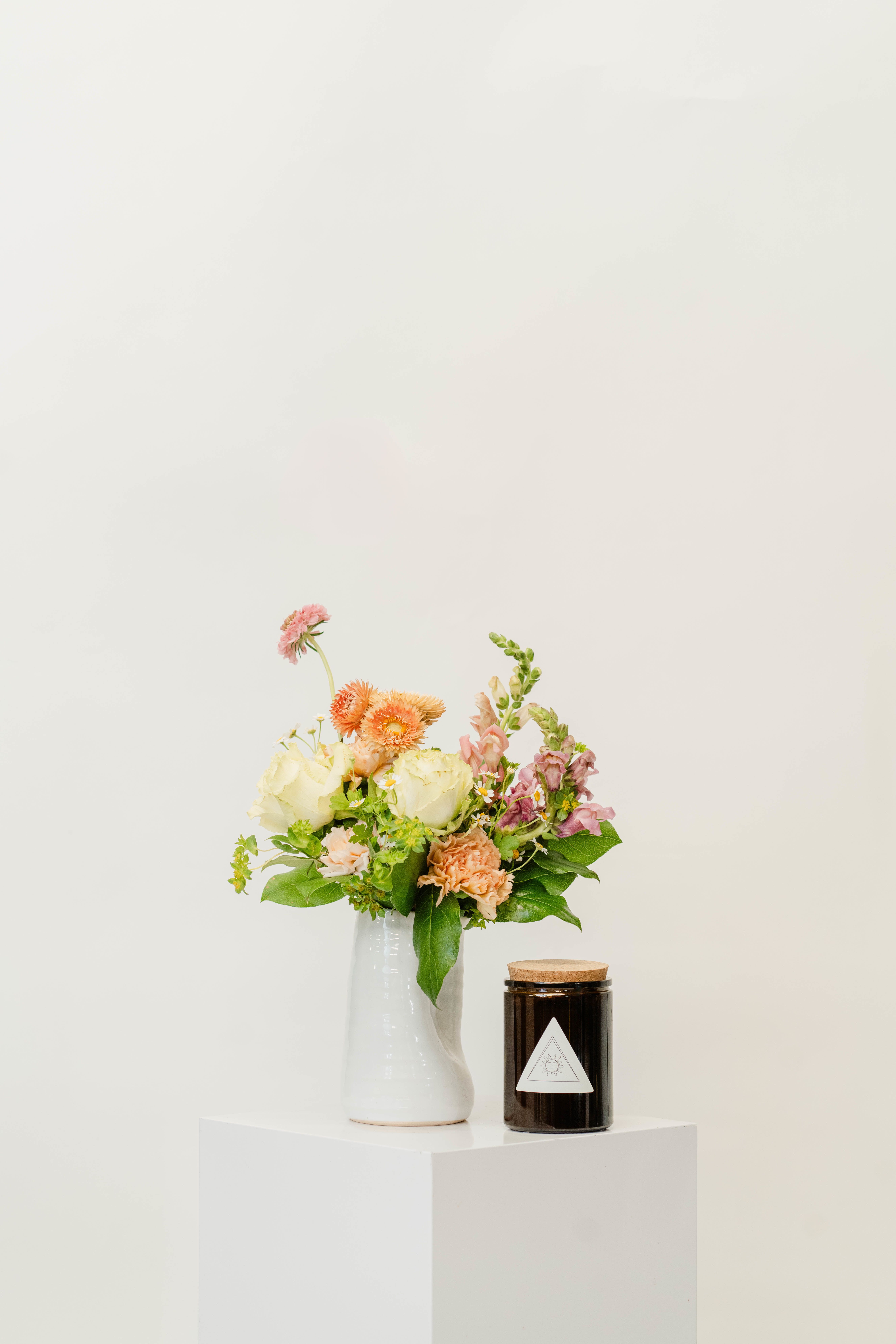 Small Vase Design + Candle Bundle - Our small curated case design bundle features a vibrant, fresh floral arrangement paired with a handcrafted candle by That Witch Apothecary, bringing natural beauty and warmth to any space. Perfect for brightening your home or gifting, this bundle is designed to create a refreshing and inviting atmosphere.        