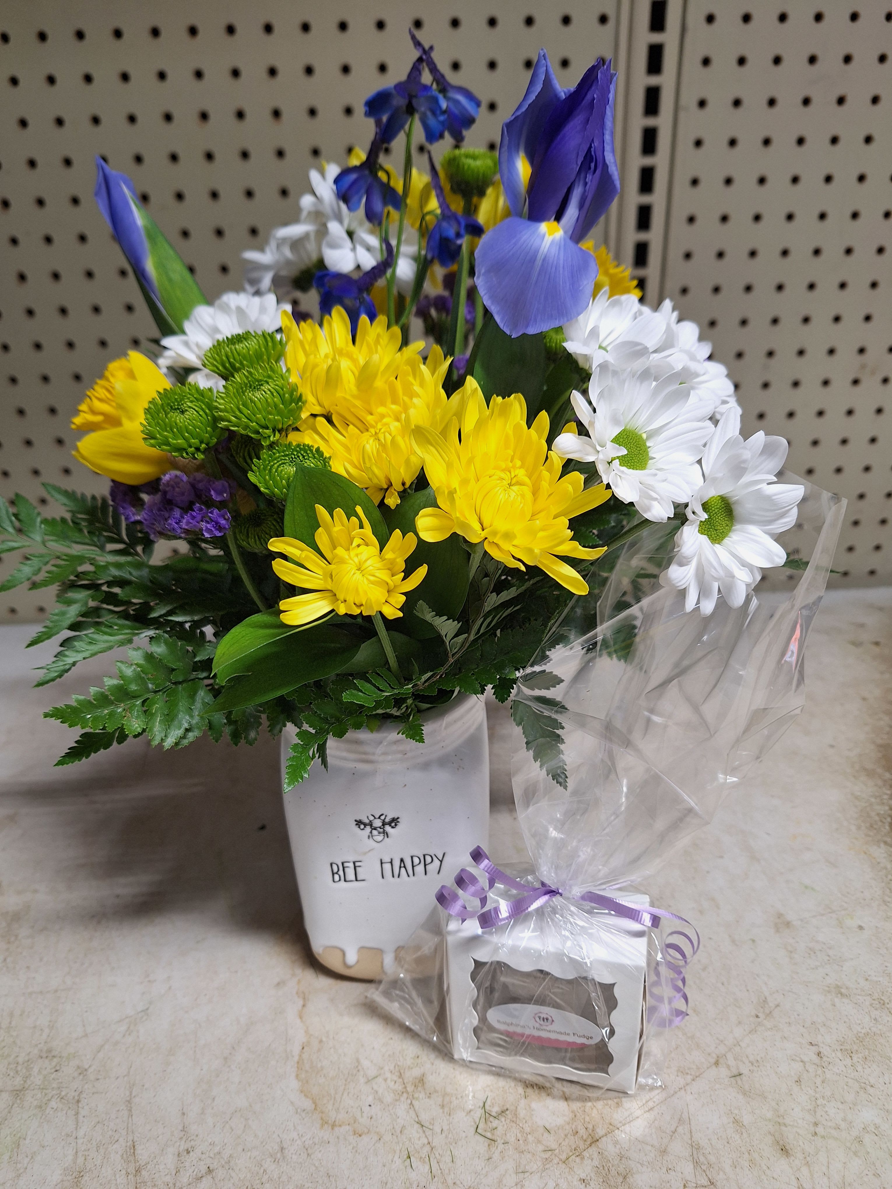 Busy Bee Bouquet - Bee Happy mason jar filled with iris, daisys, green buttons, yellow chrysanthemums, daffodils and purple status. Arrangement comes with Ralphina's homemade fudge