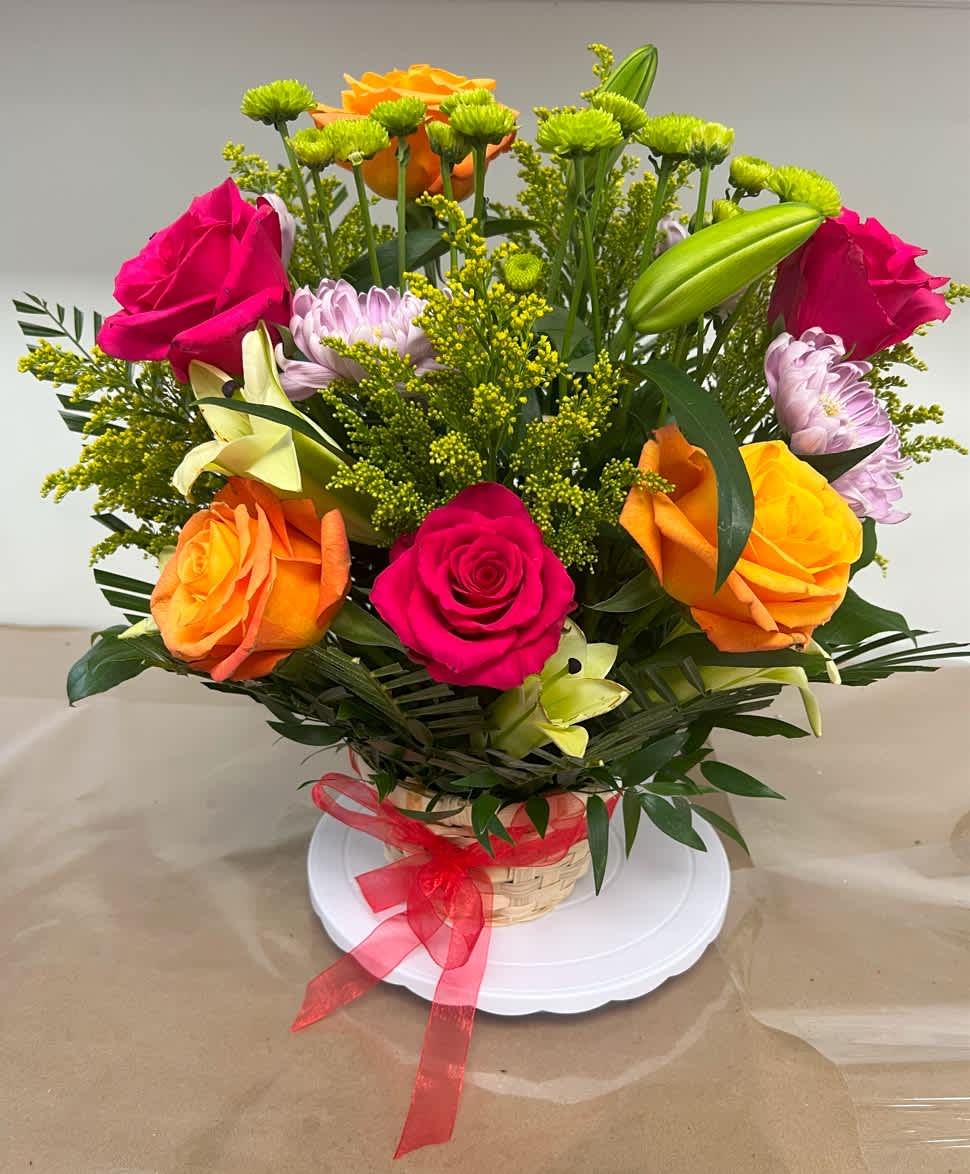 Multi Color Roses, Daisies, and Lilies Arrangement in a Rustic Basket Multi Color Roses, Daisies, and Lilies Arrangement in a Rustic Basket - Assorted roses, daisies, lilies, decorated with solidago (goldenrods), Italian ruscus, and palm leaves.
