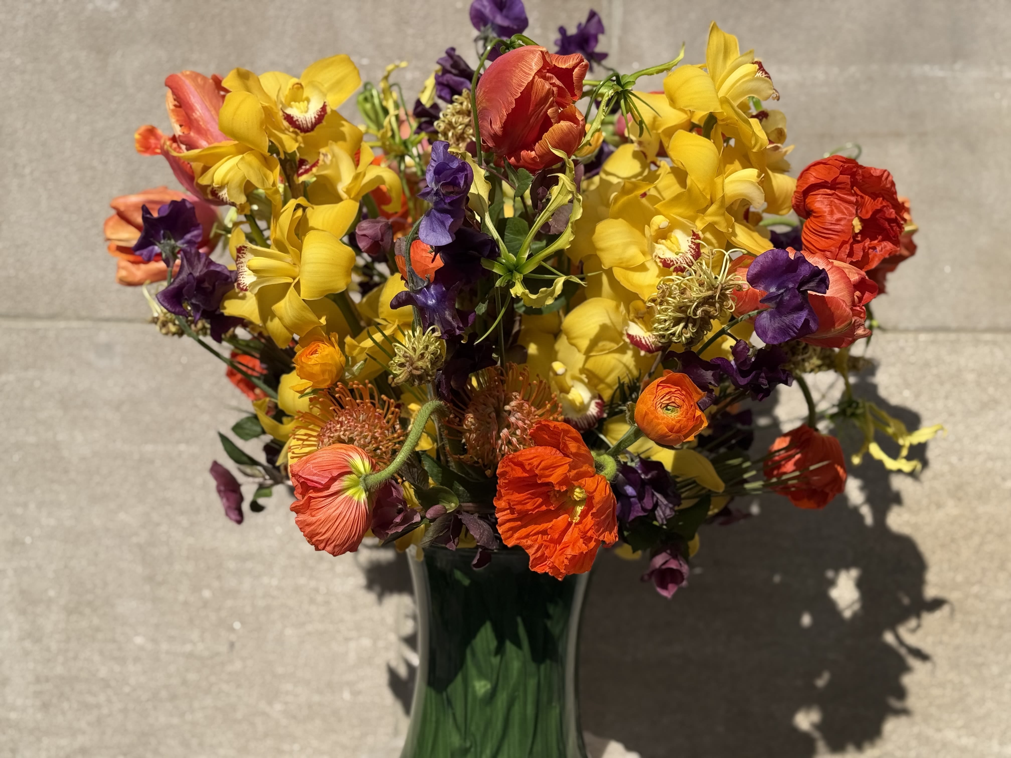 &quot;Outside In&quot;!  - Flowers by Philip is thrilled to introduce &quot;Outside In&quot;! This stunning floral composition features vibrant yellow cymbidium orchids and exquisite elephant poppies, all harvested in the beautiful landscapes of Italy. Surrounding these gems are delightful ranunculus and sweet peas from Southeast Italy, perfectly complemented by the striking Japanese gloriosa. This medium-sized arrangement is not just a bouquet; it’s a magnificent masterpiece that will truly elevate any space! Get ready to be captivated by its beauty!