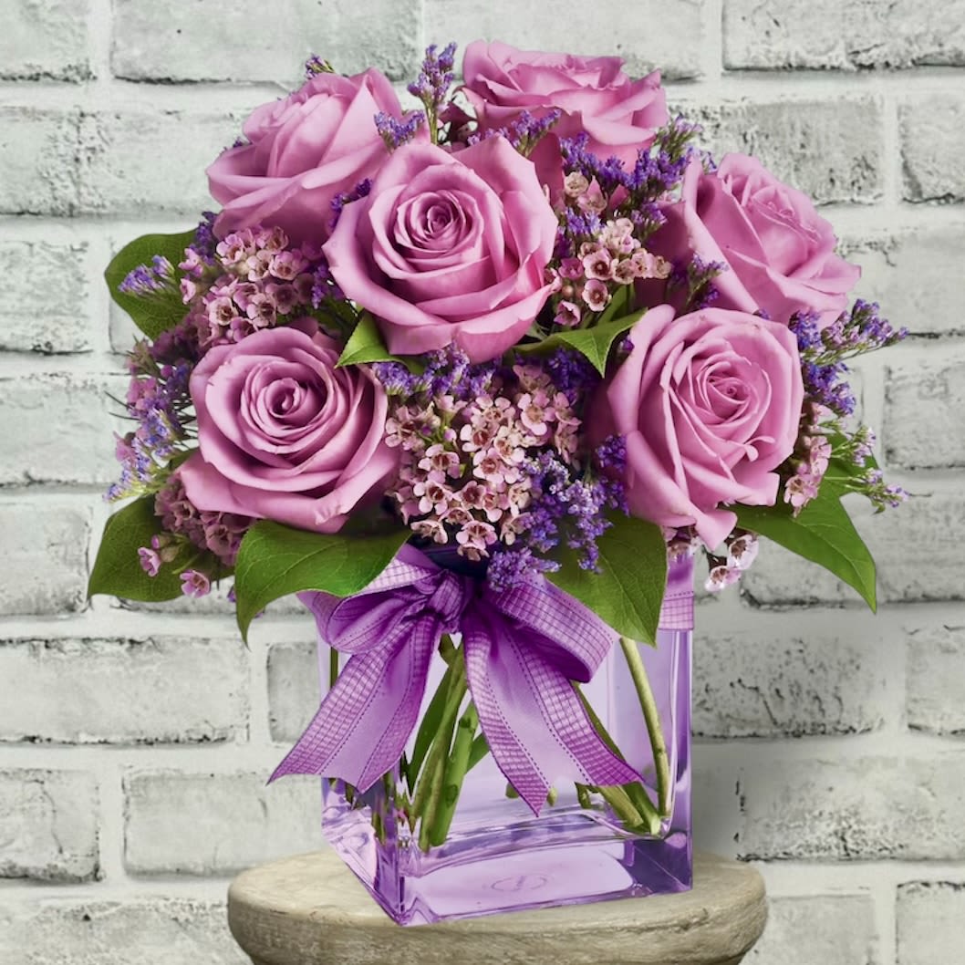 Teleflora's Morning Melody T68-3A Teleflora's Morning Melody T68-3A - Shades of purple are in perfect harmony in this profoundly pretty arrangement. A lovely mix of classic and modern, ribbons and roses, it's sure to make someone's day! Lavender roses and waxflower, purple limonium and greens are hand-delivered in a lavender cube that's all wrapped up with a vibrant purple taffeta ribbon. Approximately 10 1/2" W x 11" H Orientation: One-Sided As Shown : T68-3A Deluxe : T68-3B Premium : T68-3C