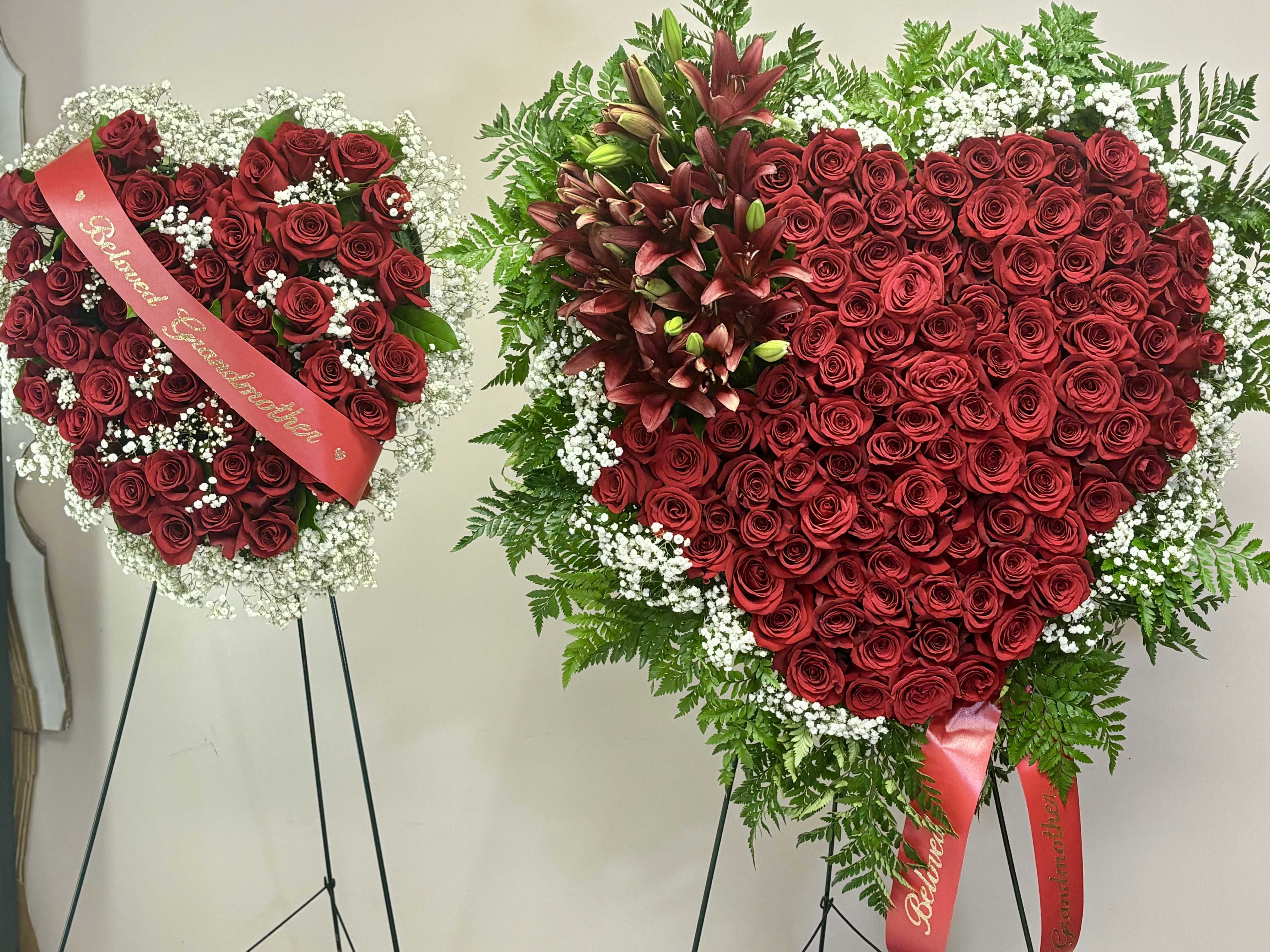 Bleeding Heart Standing Spray Bleeding Heart Standing Spray - A powerful symbol of deep love and heartfelt remembrance, our Bleeding Heart Standing Spray is crafted with rich red roses arranged in a striking heart shape, accented with lush greenery and flowing red ribbon for an emotional, elegant finish. Measuring 24 inches wide, this standing spray is a timeless tribute to someone dearly missed, expressing devotion, sorrow, and unending affection with every bloom. Perfect for memorials, funerals, and celebration of life services, this piece speaks when words fall short. Features: 24" wide heart shape Fresh premium red roses Layered greenery for texture and contrast Finished with cascading red ribbon Available for delivery only. Custom color options available upon request. Let us help you honor your loved one with grace and beauty.