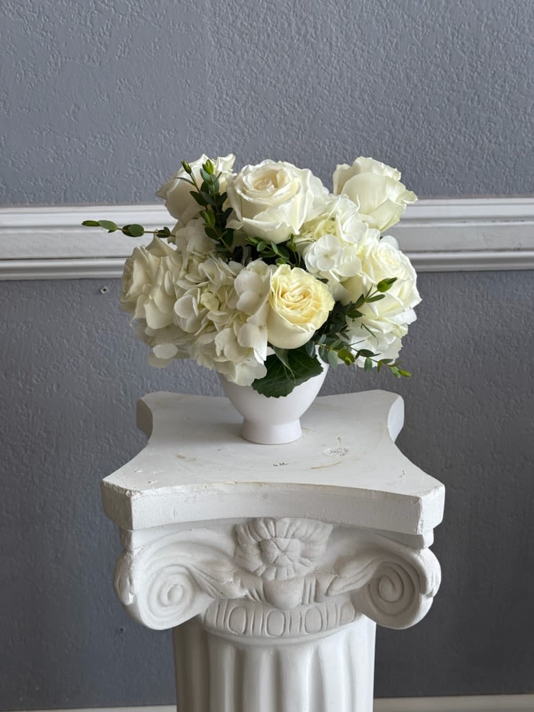 Snow White Snow White - Compote arrangement all in white florals. This arrangement can be perfect for sympathy, weddings or the loved one who appreciates a monogrammatic floral arrangement.