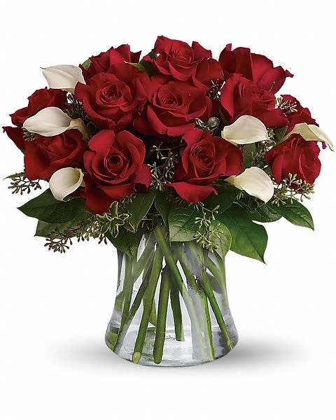 Be Still My Heart - Dozen Red Roses - The look of love is charmingly reflected in this romantic array of red roses and fragrant white callas. Beautifully presented in a sparkling glass vase, these gorgeous flowers will say what's in your heart more eloquently than words. The gorgeous bouquet features one dozen red roses and a half dozen miniature white calla lilies accented with assorted greenery.  