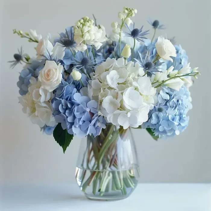 The Sky Above - A collection of blue and white hydrangea, roses, thistle and stock reminiscent of the majestic sky. This stunning arrangement will speak a world of love from your heart to theirs. 