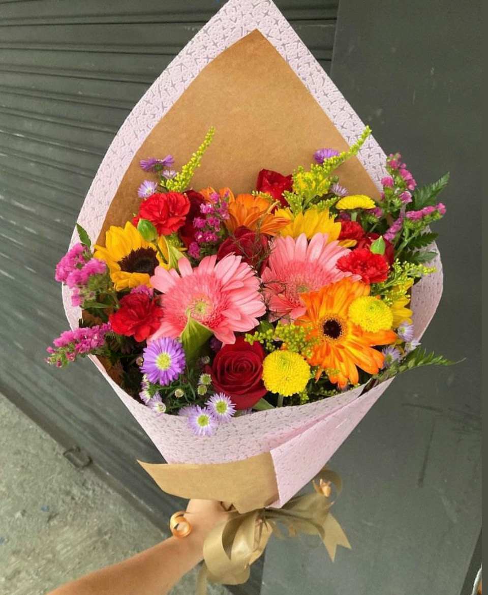 Spring Flower Bouquet - Spring Flower Bouquet of Sunflower, Gerberas, Carnations, Roses, Bottom Pom or Daises with Montecasino, Solidago, and Statice accents. Paper and Flower color may vary depending on availability
