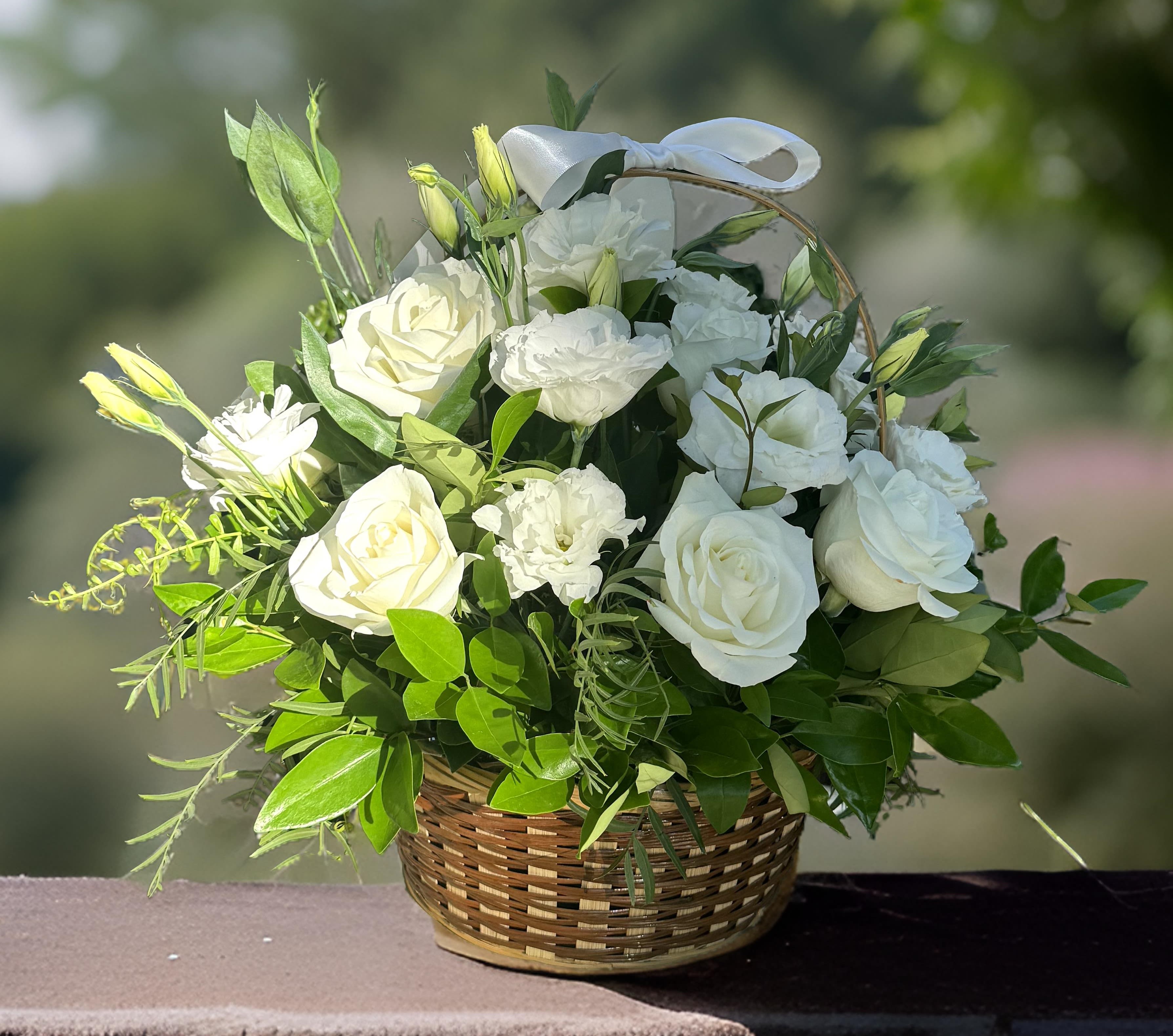 Flowers &quot;White Serenity Basket&quot; - This elegant flower basket is filled with classic white roses and delicate lisianthus, creating a timeless and sophisticated floral arrangement. The soft white blooms symbolize purity and grace, making this arrangement perfect for a variety of occasions. Just like the funeral homes, wedding venues, and office buildings where we offer flower delivery, this bouquet brings a touch of elegance and beauty to any space. Whether you're sending a heartfelt tribute, celebrating love, or brightening up a professional setting, this luxury floral arrangement will make a lasting impression. Available for delivery in Los Angeles, this exquisite basket of white roses and lisianthus is the perfect choice for any special occasion