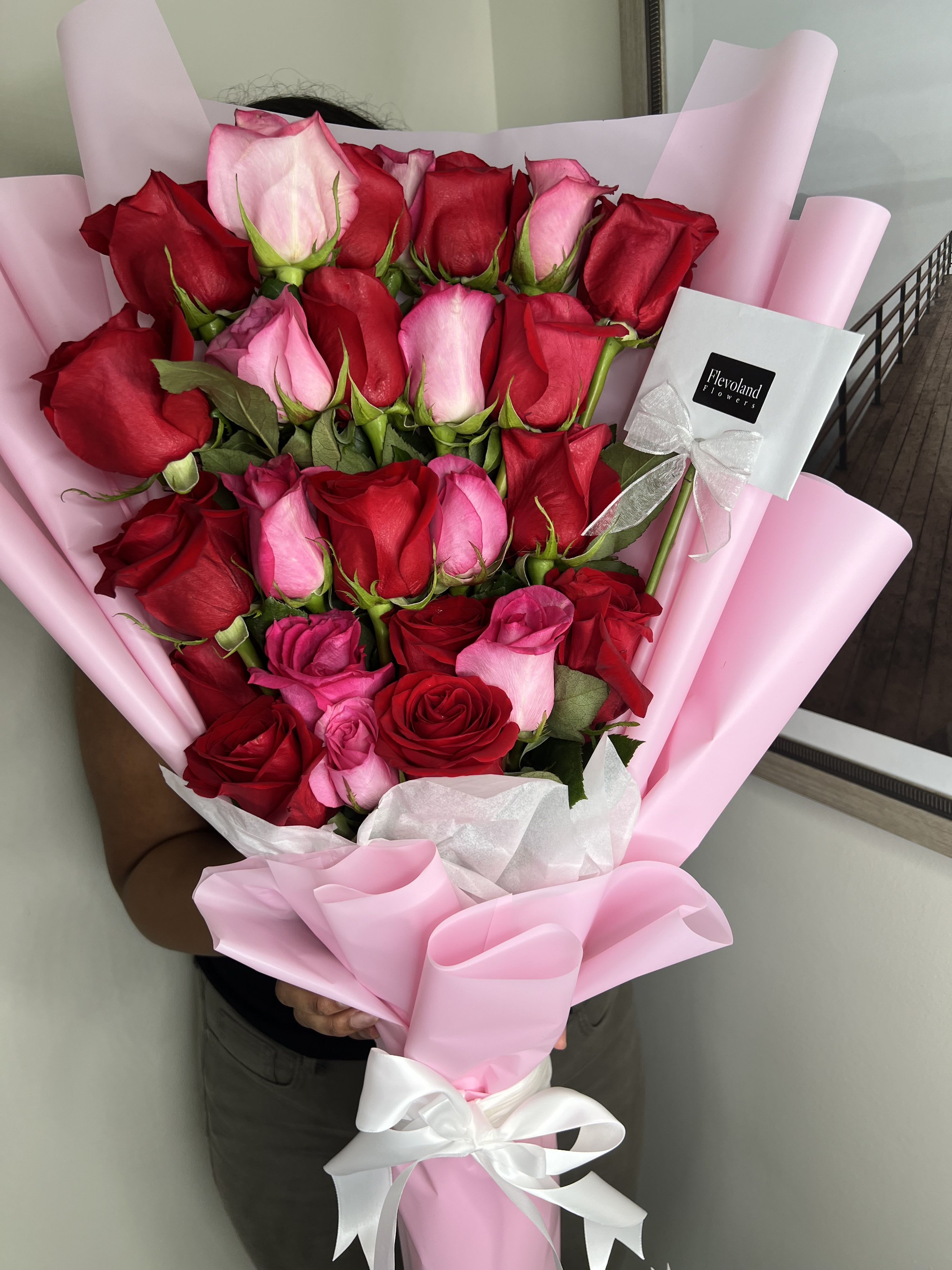 Bouquet of Beauty in Height - A beautiful arrangement of roses displayed in a column, wrapped in delicate pink paper that enhances their charm. Perfect for conveying elegance and beauty for any special occasion.
